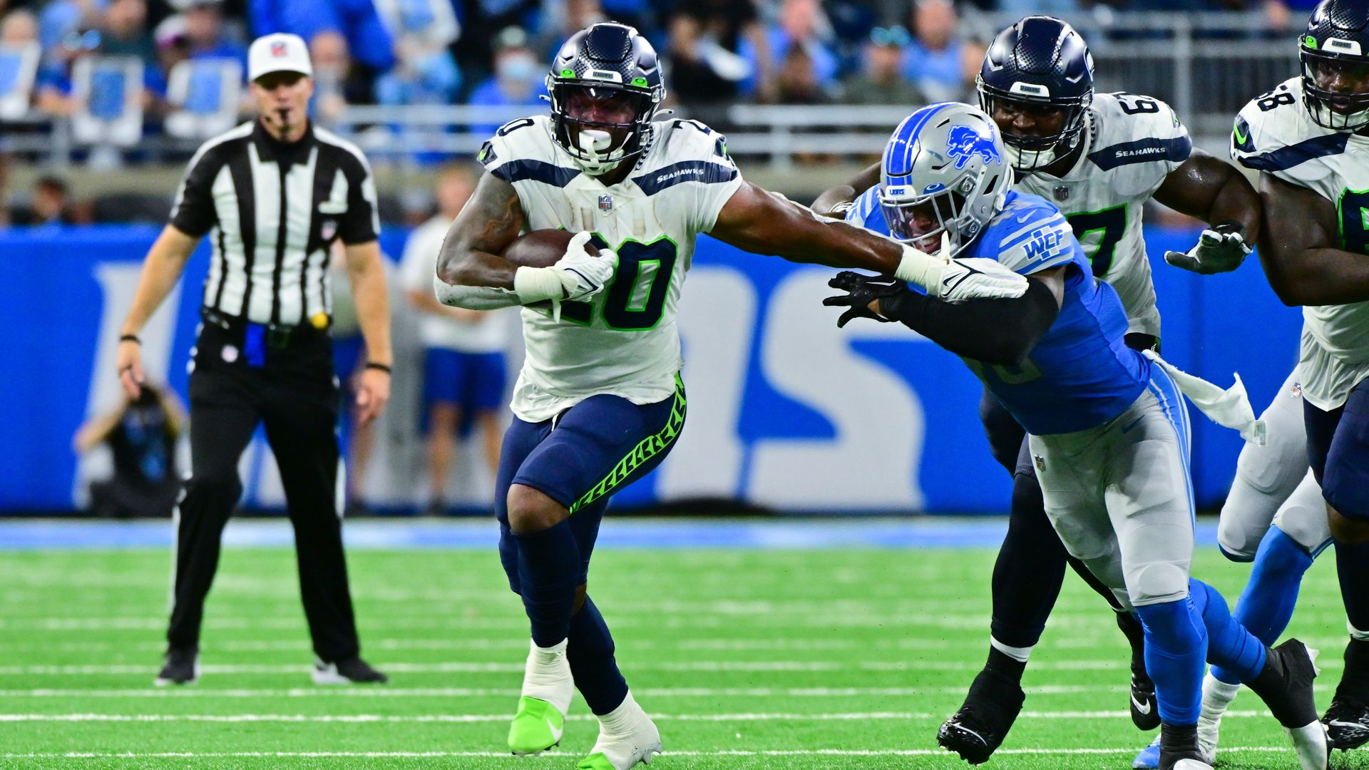 Seattle Seahawks running back Rashaad Penny stiff arms a Lions defender.