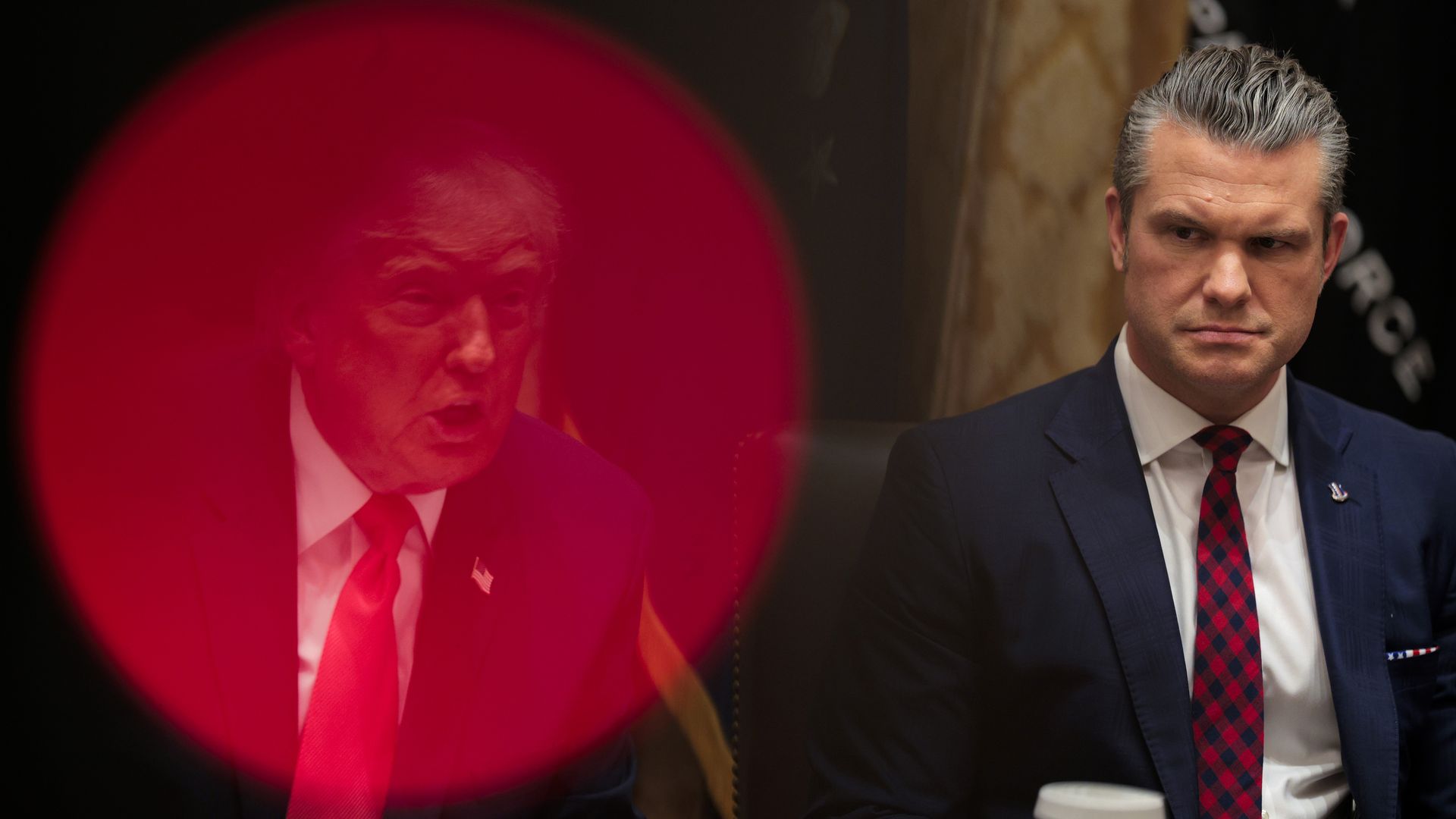 Man in navy blue suit and red checkered tie seated looking to the side (Hegseth), with another man faintly visible behind a large red circle on the left side of the image (Trump).