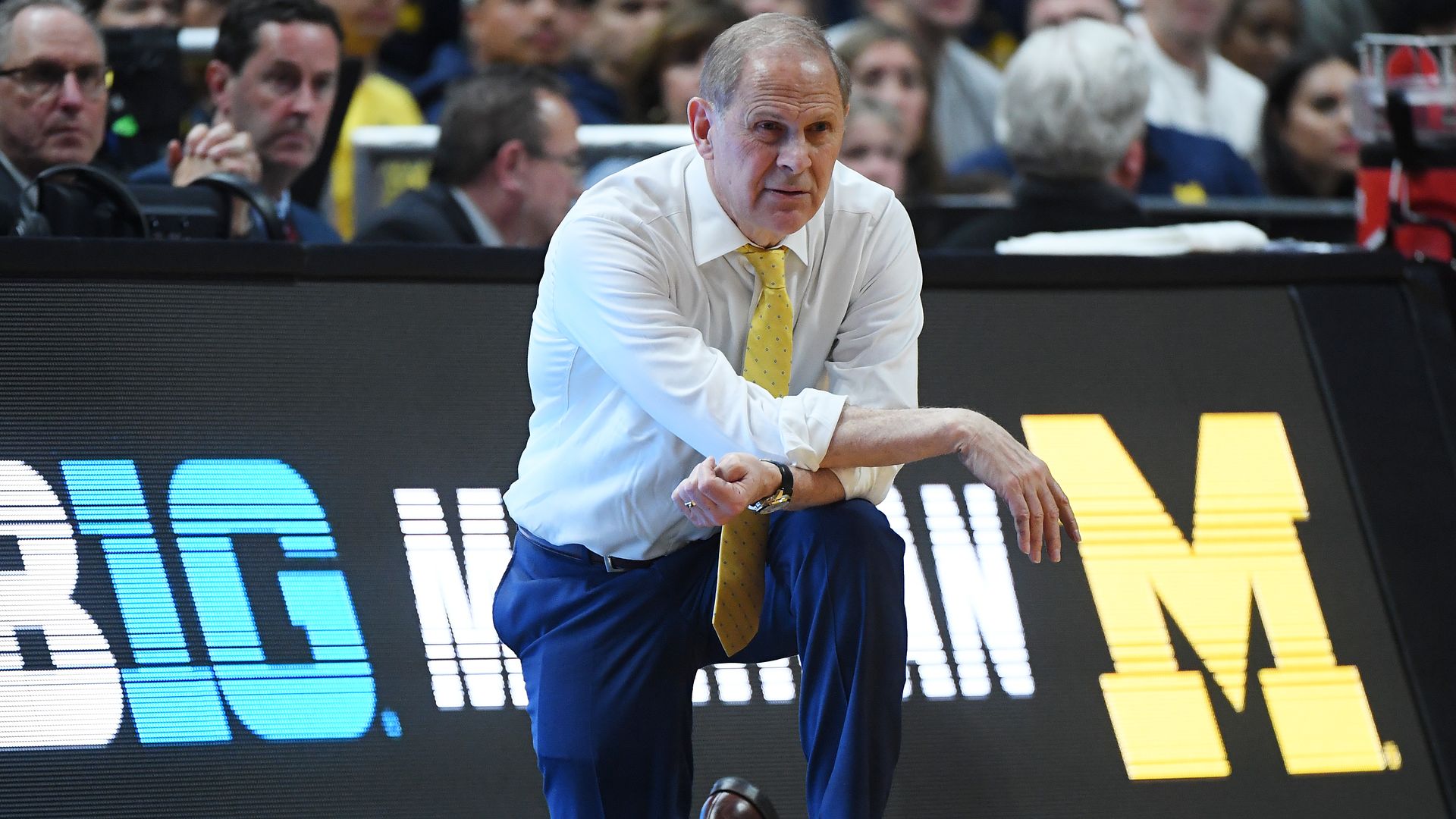 John Beilein kneeling on the sideline