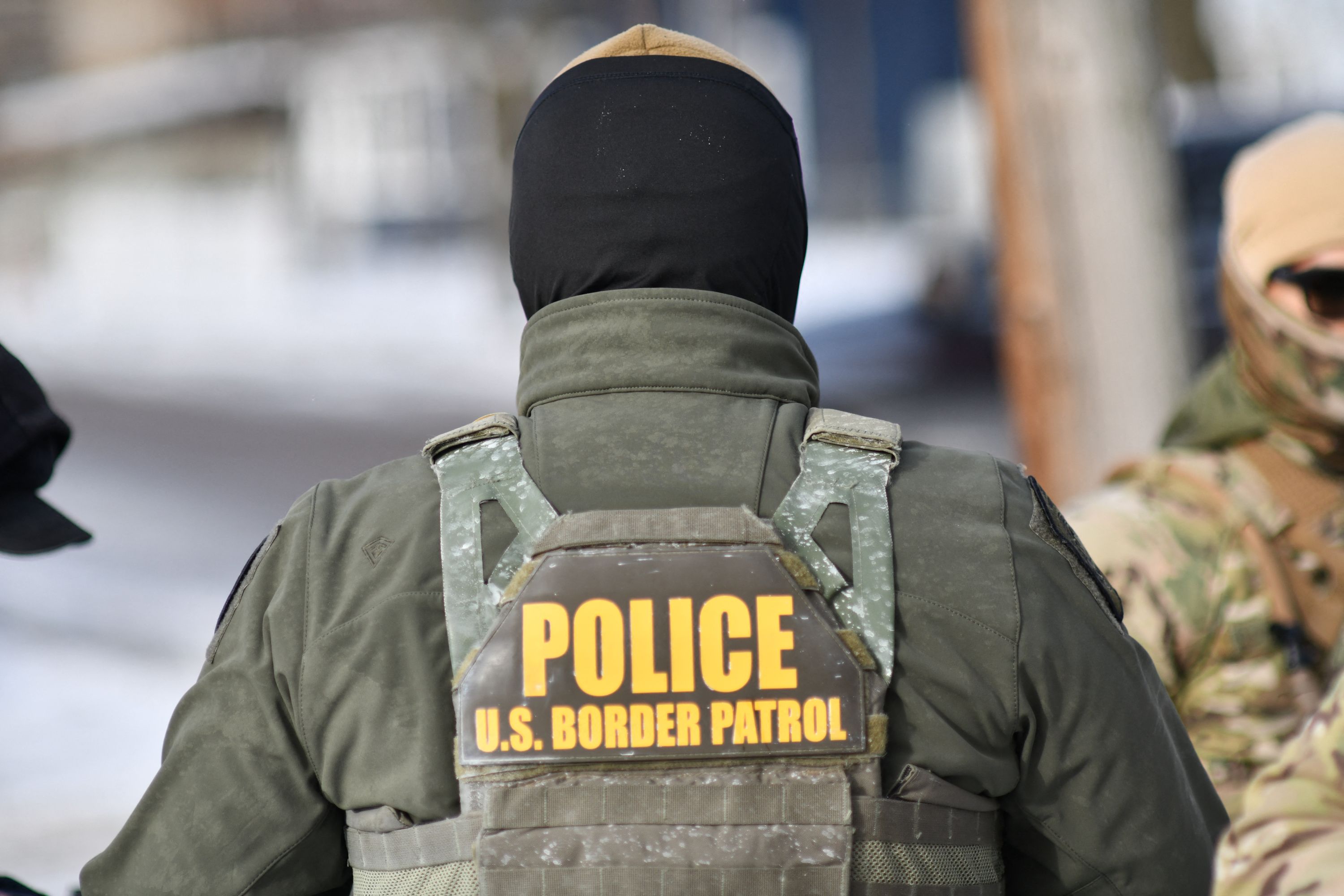 U.S. Customs and Border Protection agents walk down a residential street in Minneapolis during a federal immigration enforcement operation that has drawn protests after an ICE agent fatally shot a local woman.