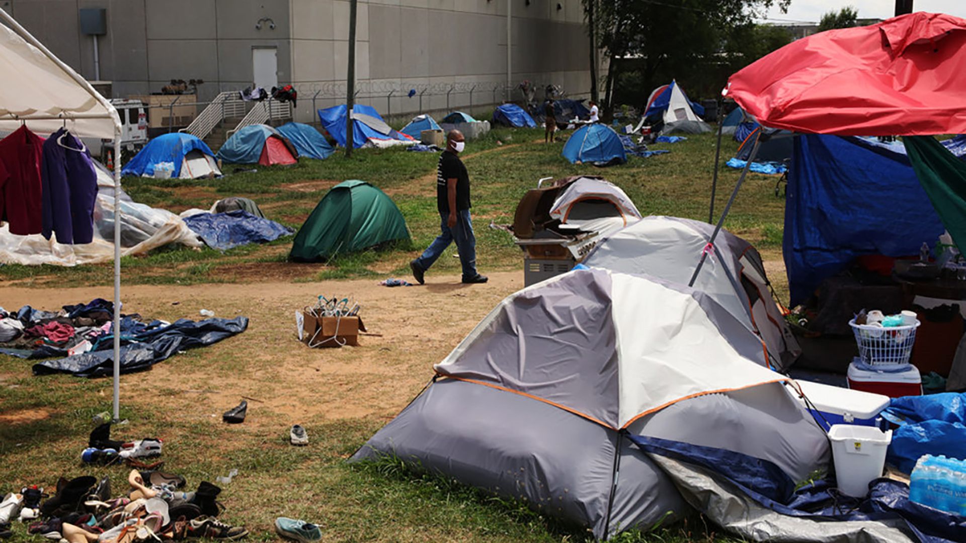 image of homeless encampments with tents and a man walking, taken during summer 2020