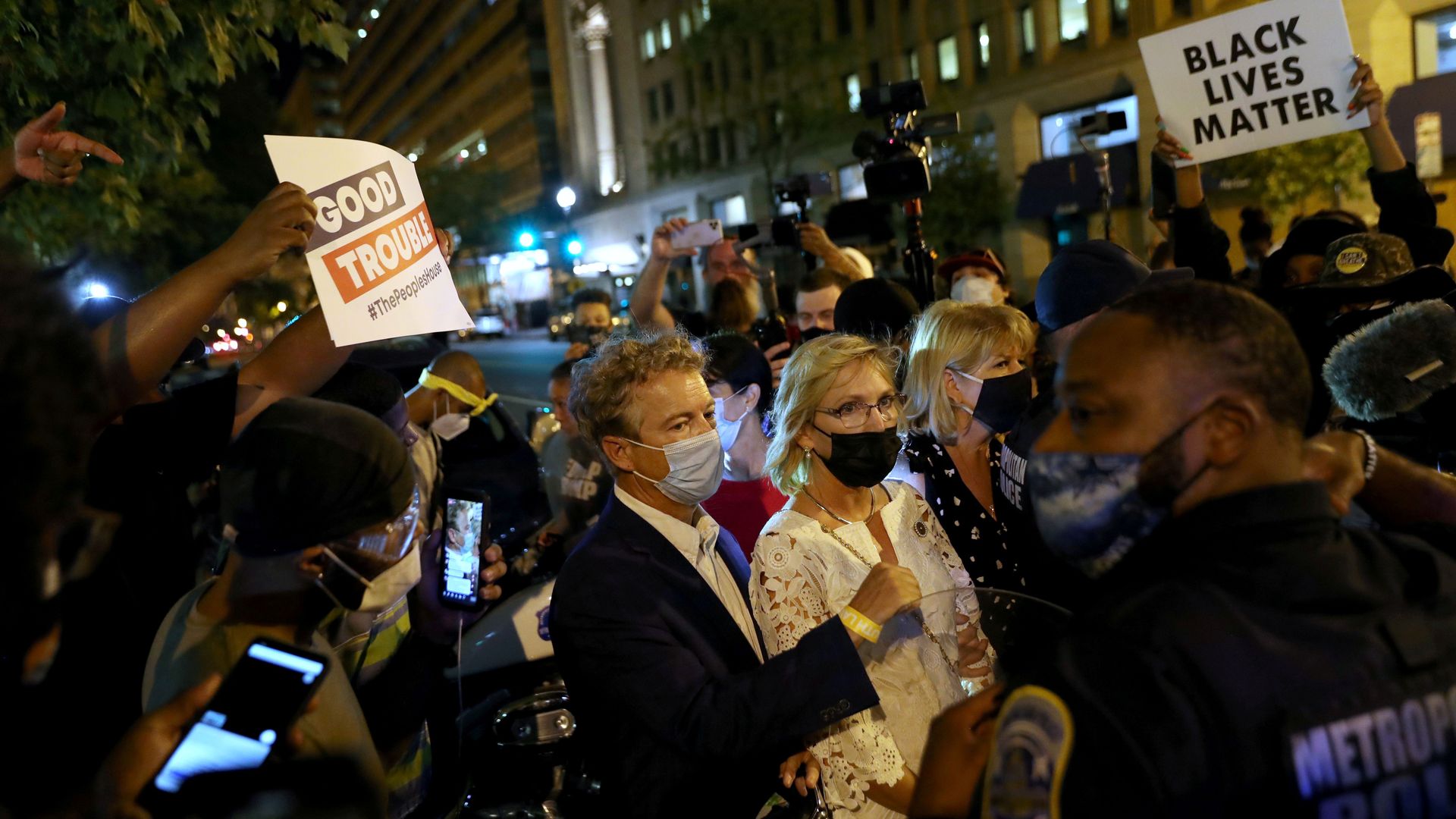 Rand Paul surrounded by a crowd of protesters