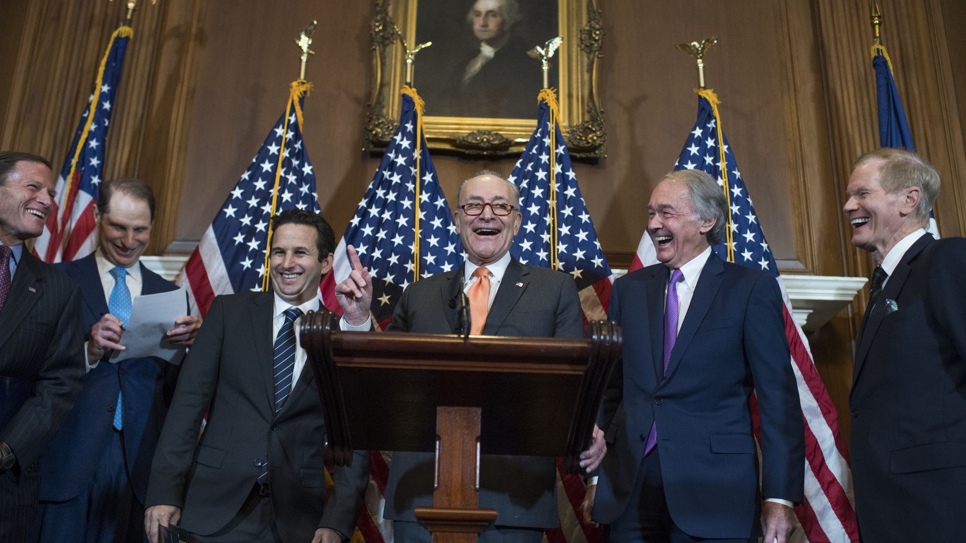 Sen. Chuck Schumer at a podium, surrounded by other Senate Democrats