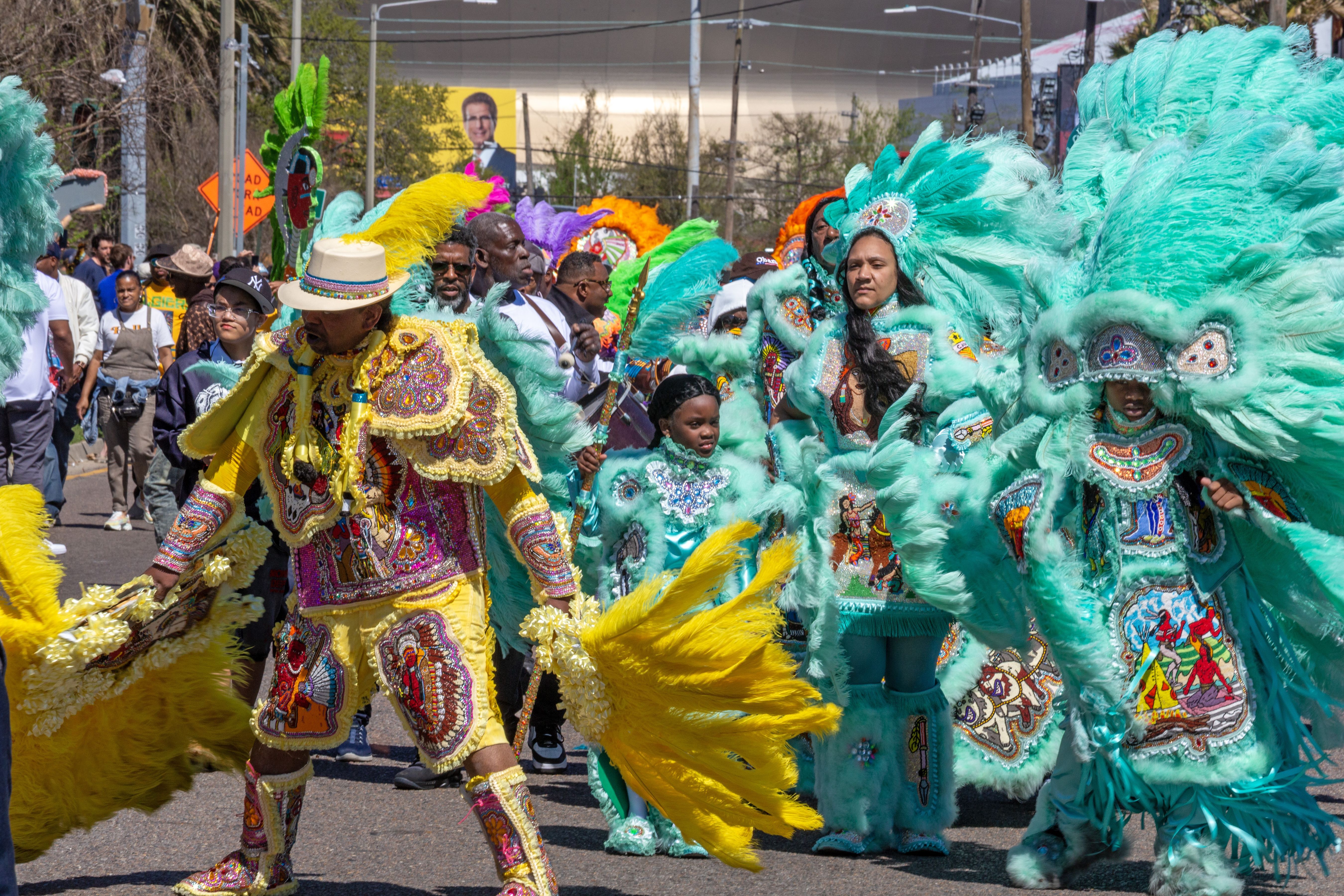 Image shows Mardi Gras Indians in colorful feather suits.
