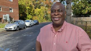 Lenwood Johnson poses outside his apartment building