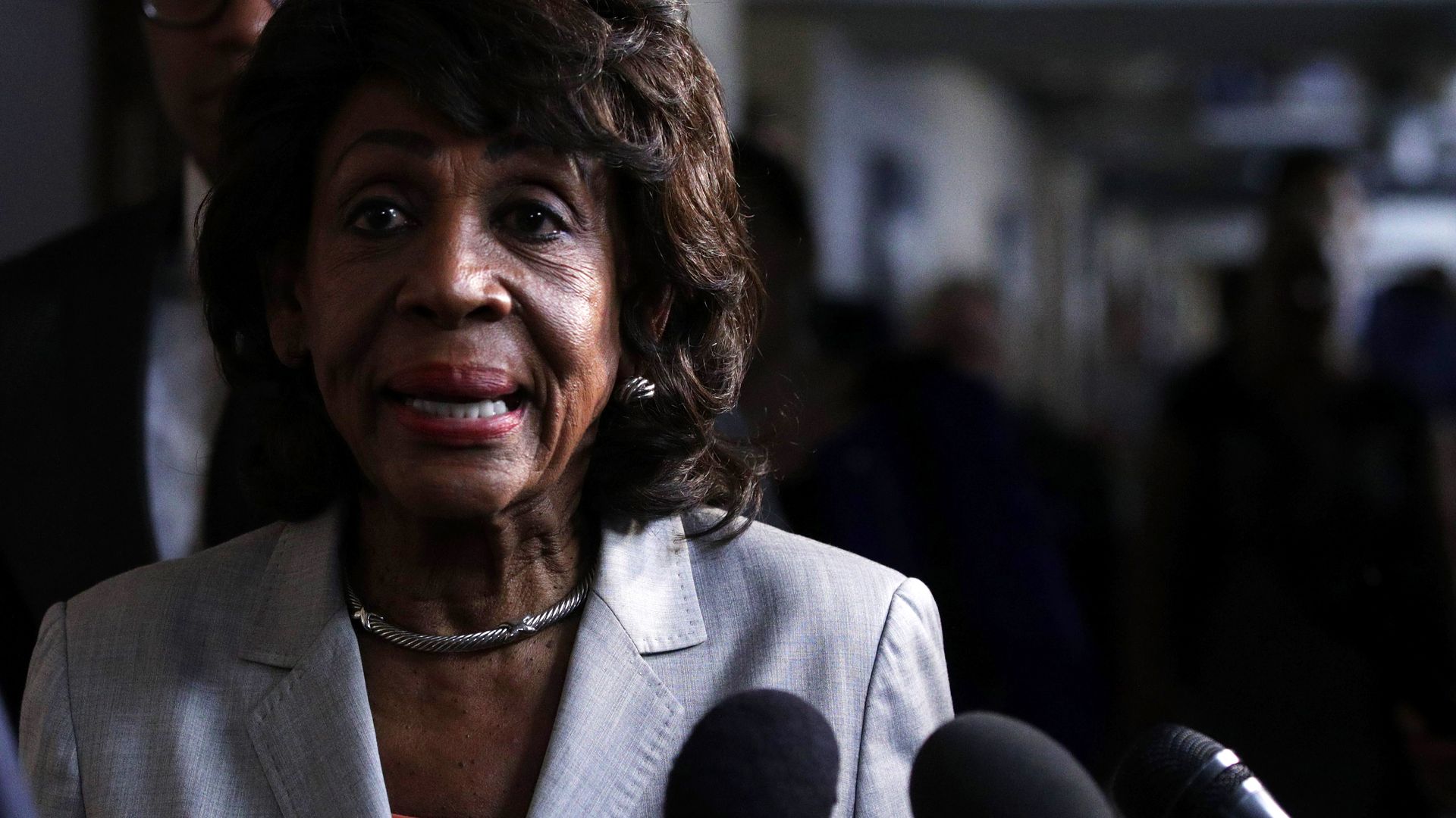 In this image, Waters speaks into several microphones 