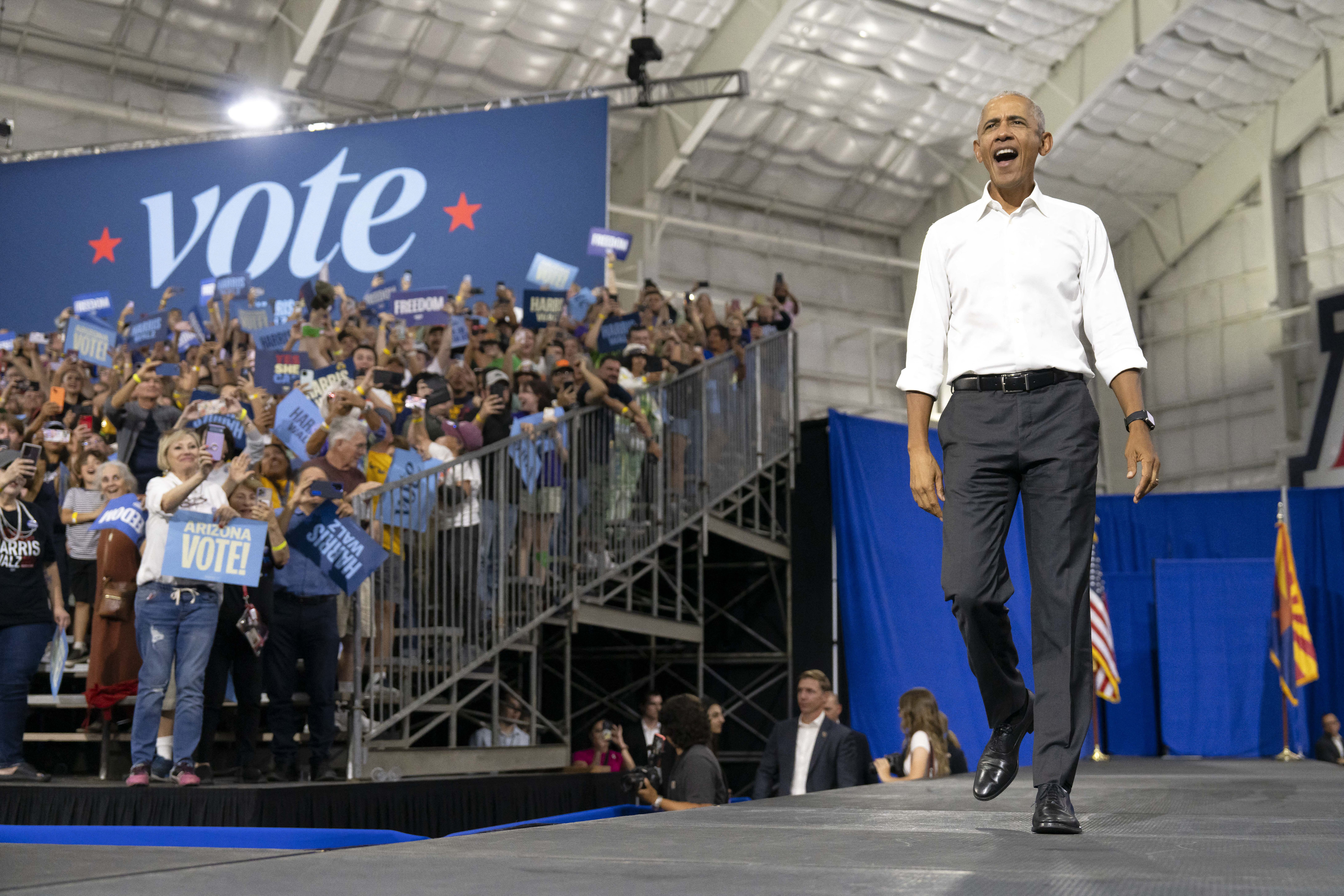 Former US President Barack Obama walks on stage during a Get-Out-The-Vote campaign rally for US Vice President and Democratic presidential candidate Kamala Harris at Cole and Jeannie Davis Sports Center in Tucson