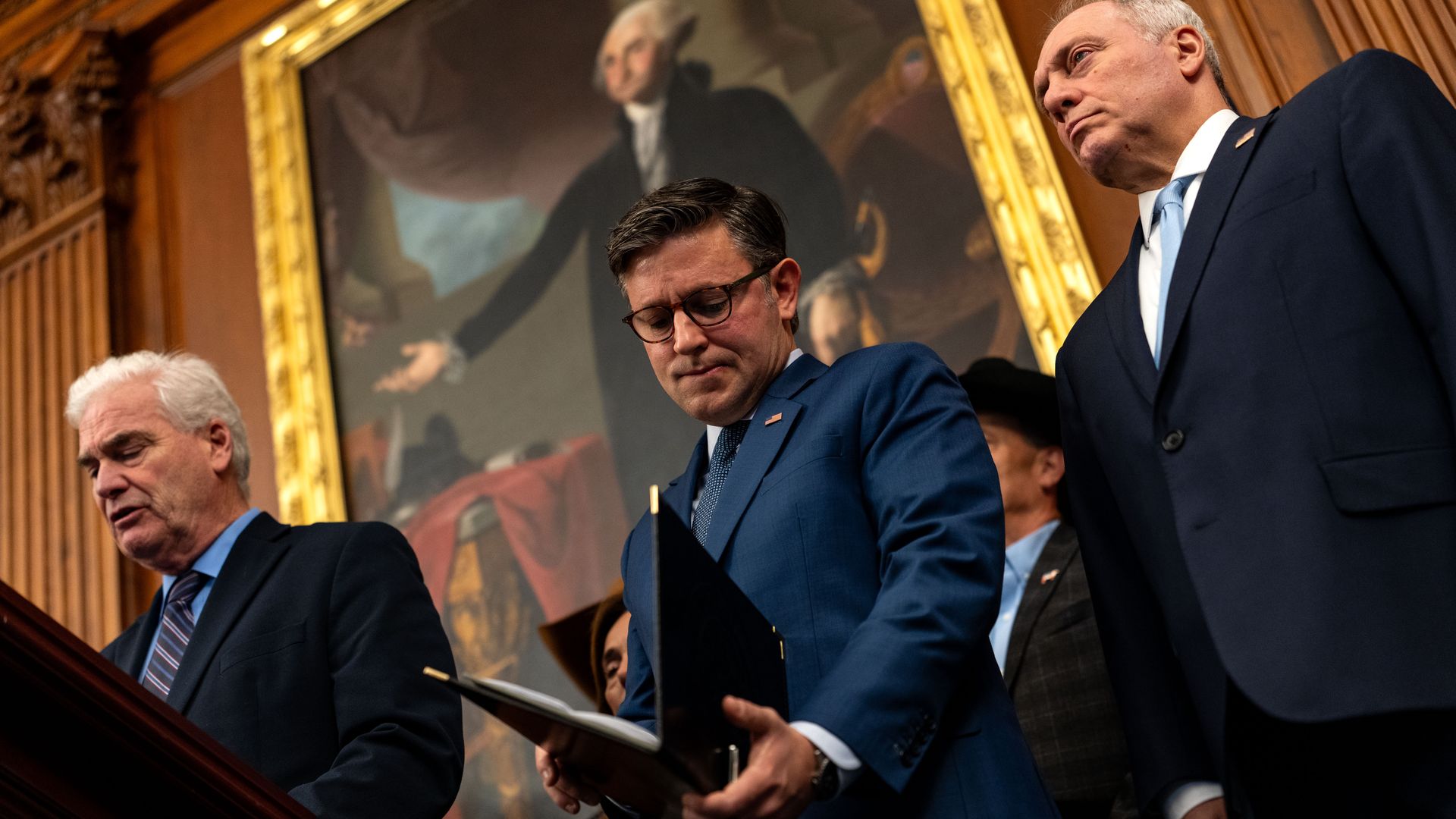 Speaker Mike Johnson looks at his notes while Majority Whip Tom Emmer is speaking at a press conference in Rayburn room in the Capitol  
