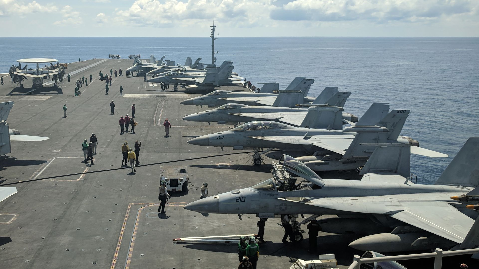Multiple planes are on top of the aircraft carrier USS Reagan in the South China Sea