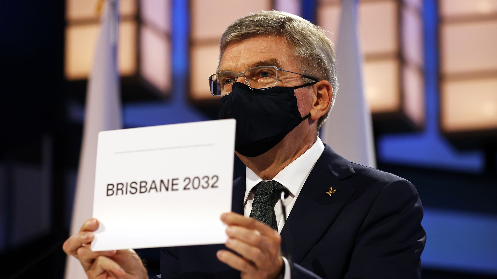 Thomas Bach holding Brisbane 2032 sign