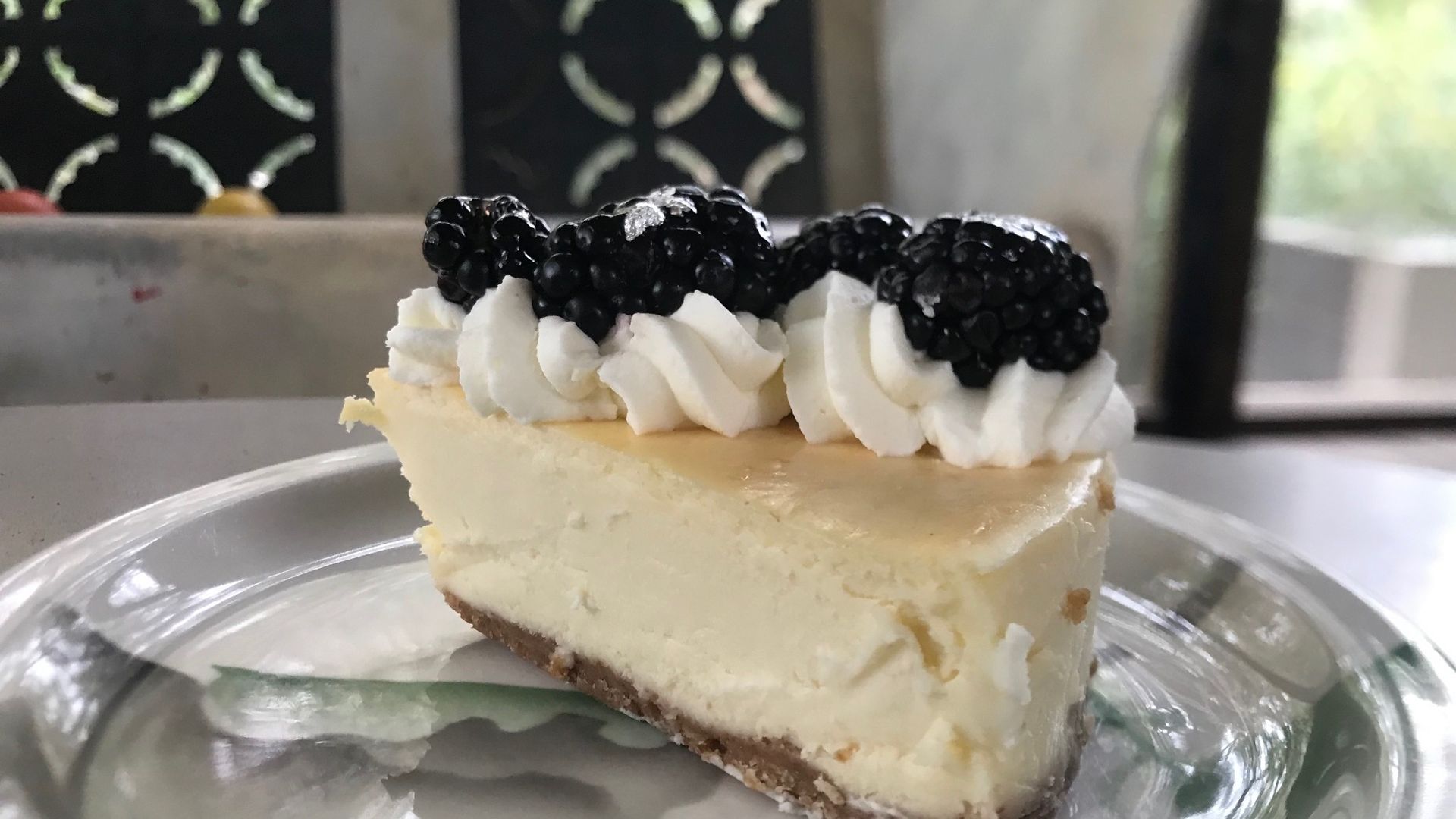 A slice of cheesecake with blackberries on top.
