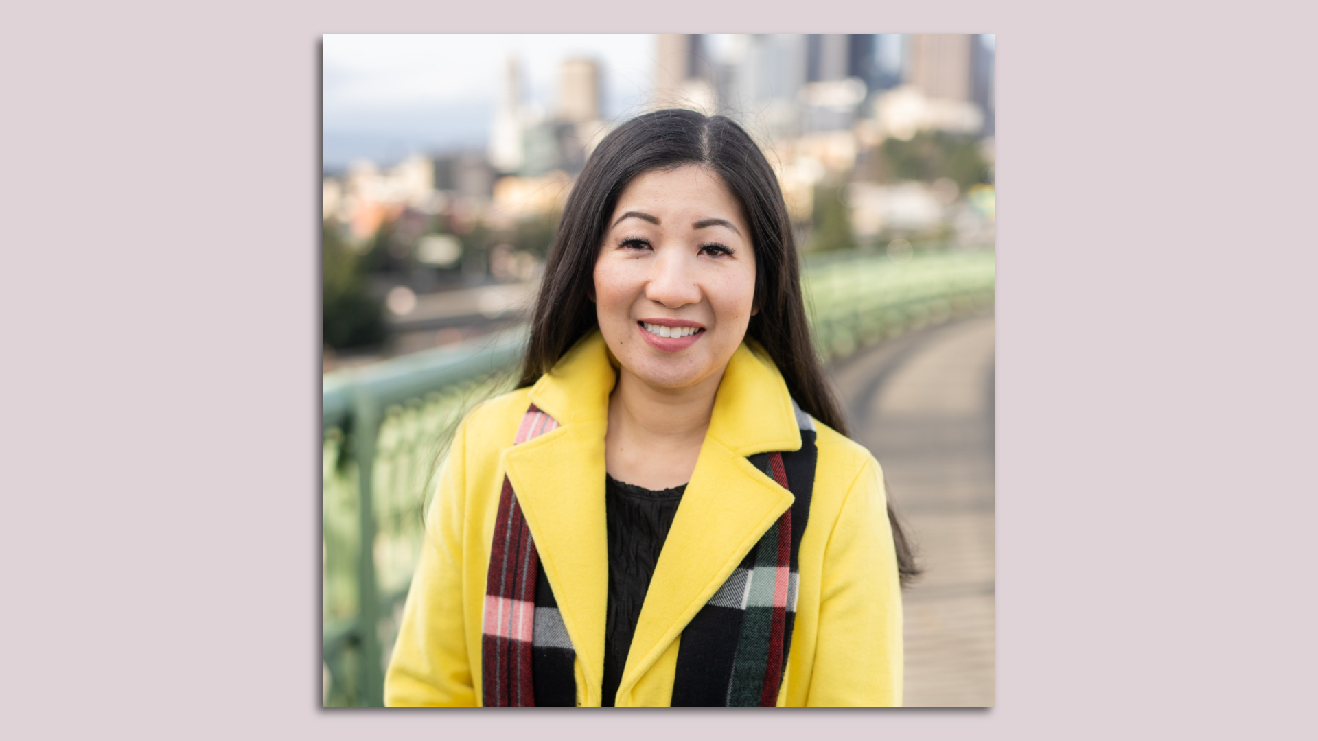 A photo of Tanya Woo in a yellow coat in front of the Seattle skyline is mounted on a background.
