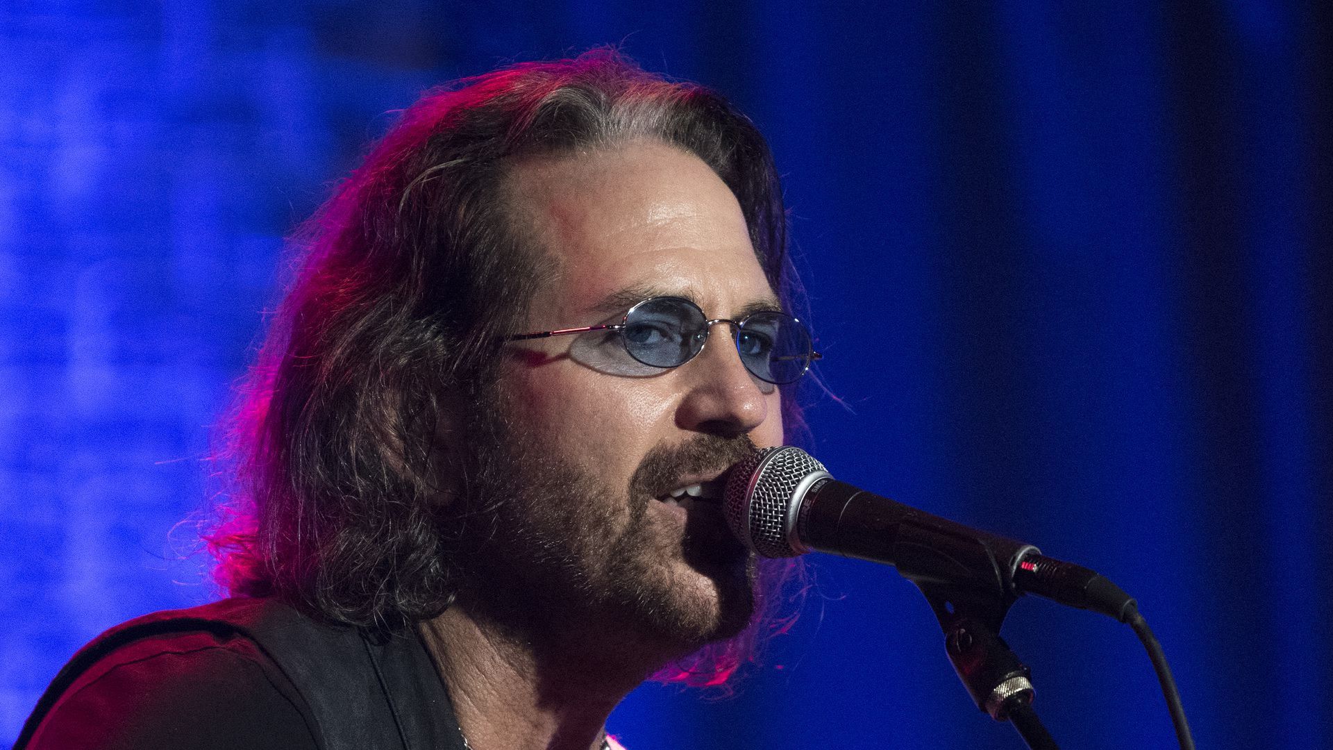 Kip Winger singing into a microphone 