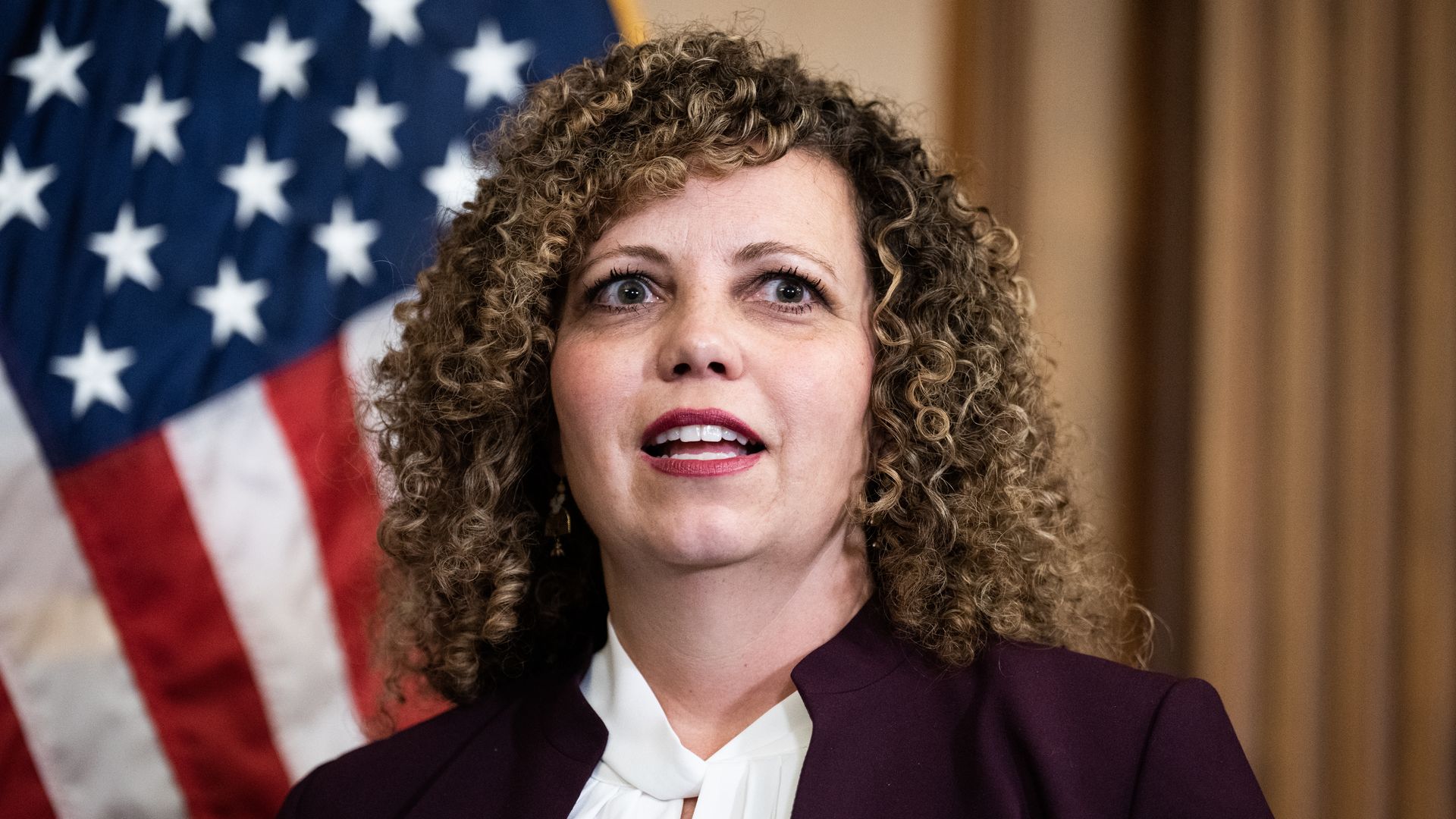 Celeste Maloy looks ahead in front of an American flag.