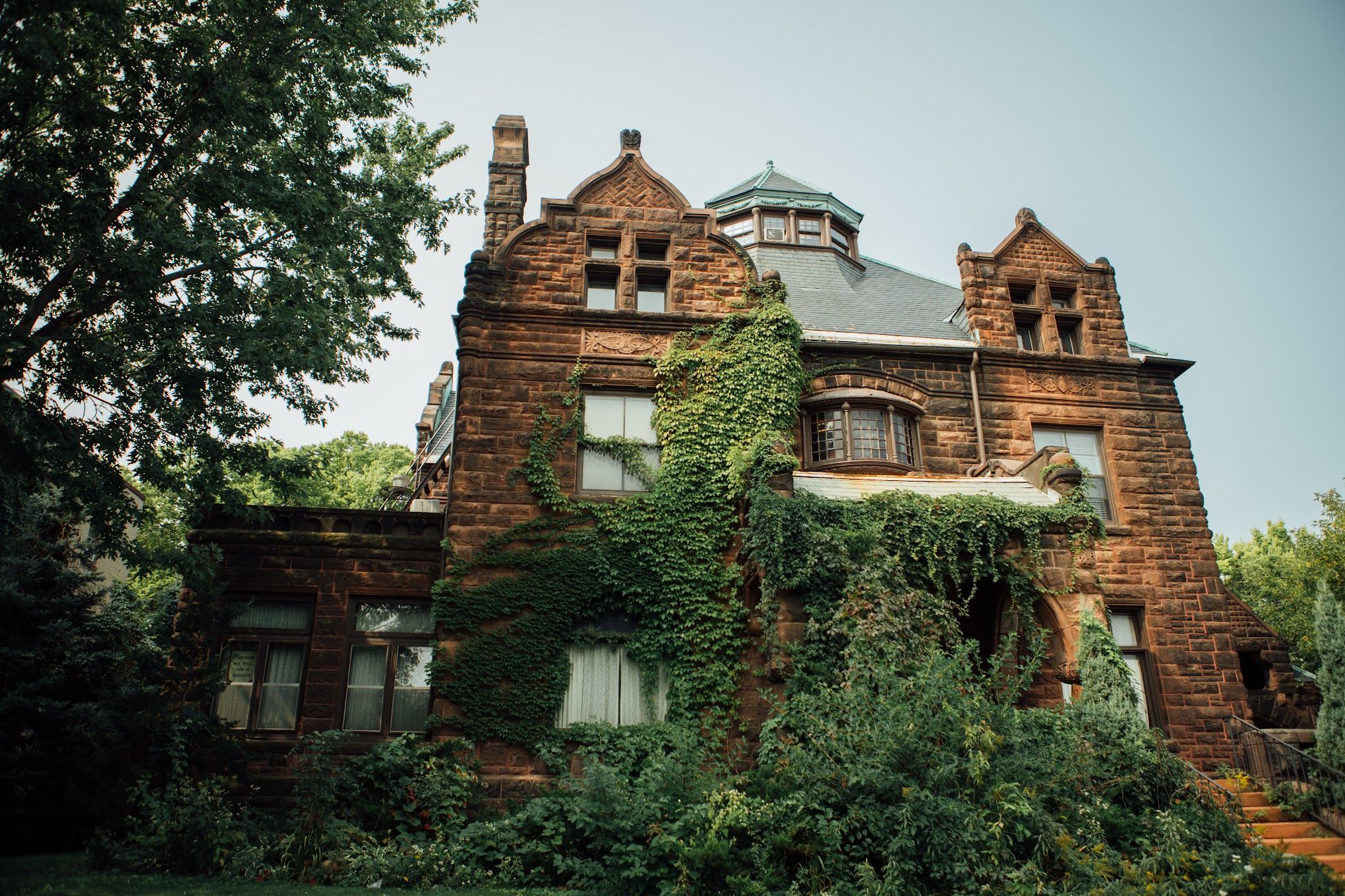 A photo of the exterior of a large brick mansion.