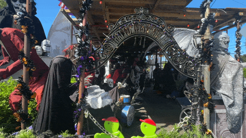 Front yard of the holiday house with an arch and moving halloween decorations