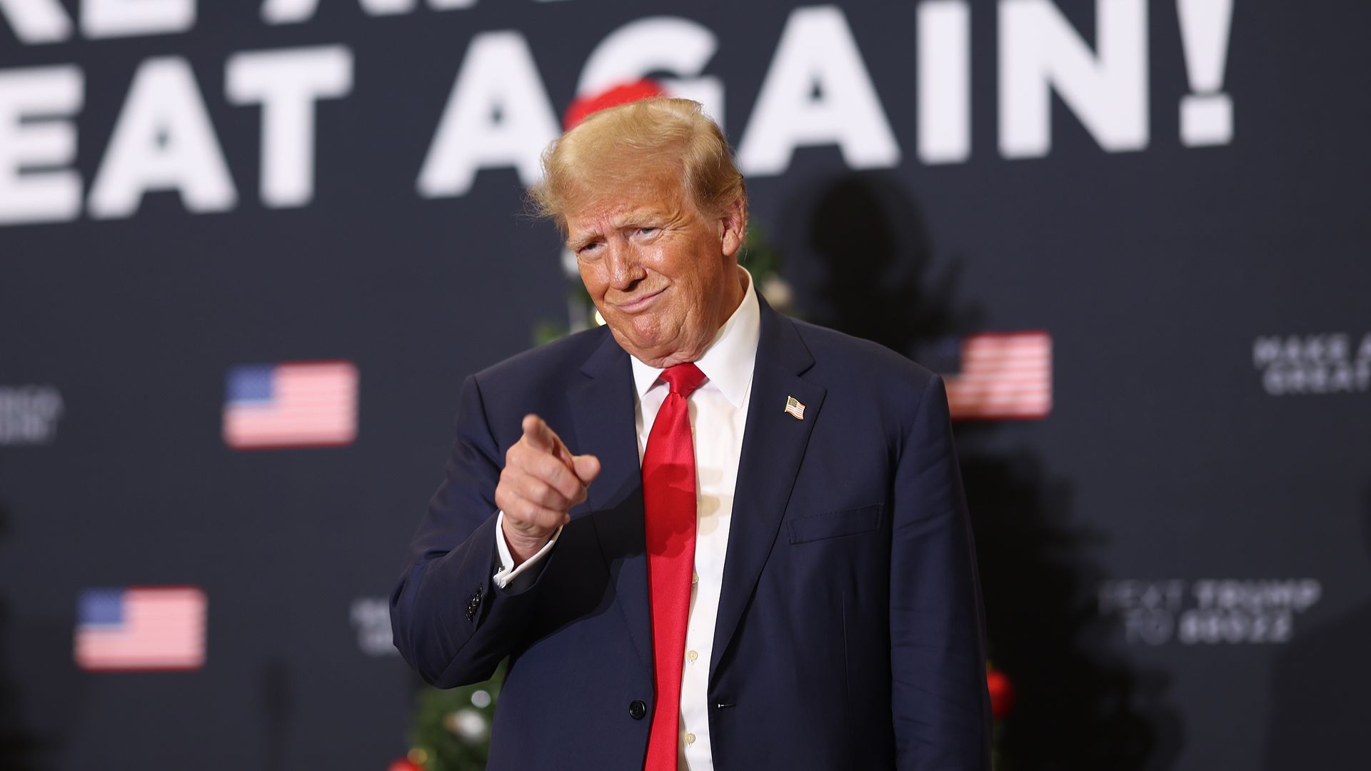 Republican presidential candidate and former U.S. President Donald Trump gestures to guests at a campaign event on December 19, 2023 in Waterloo, Iowa.