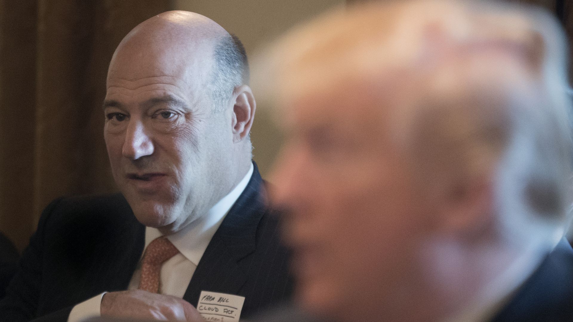 Gary Cohn, with Donald Trump's face blurred in the foreground.