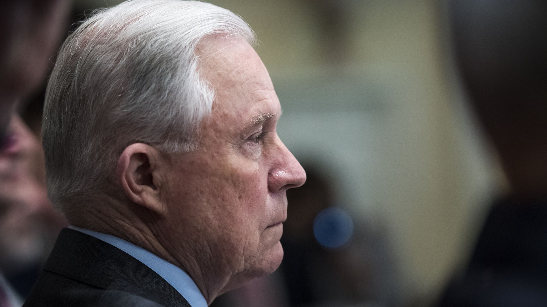 Jeff Sessions profile sitting at a table looking unhappy.