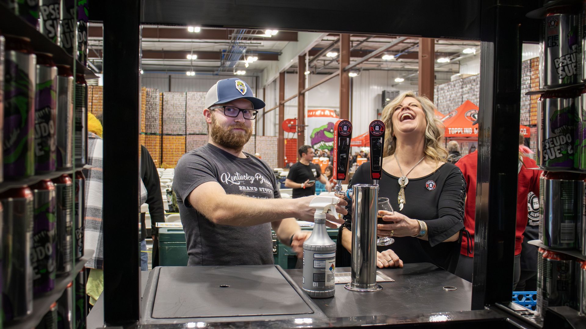 Two people getting beer at Toppling Goliath