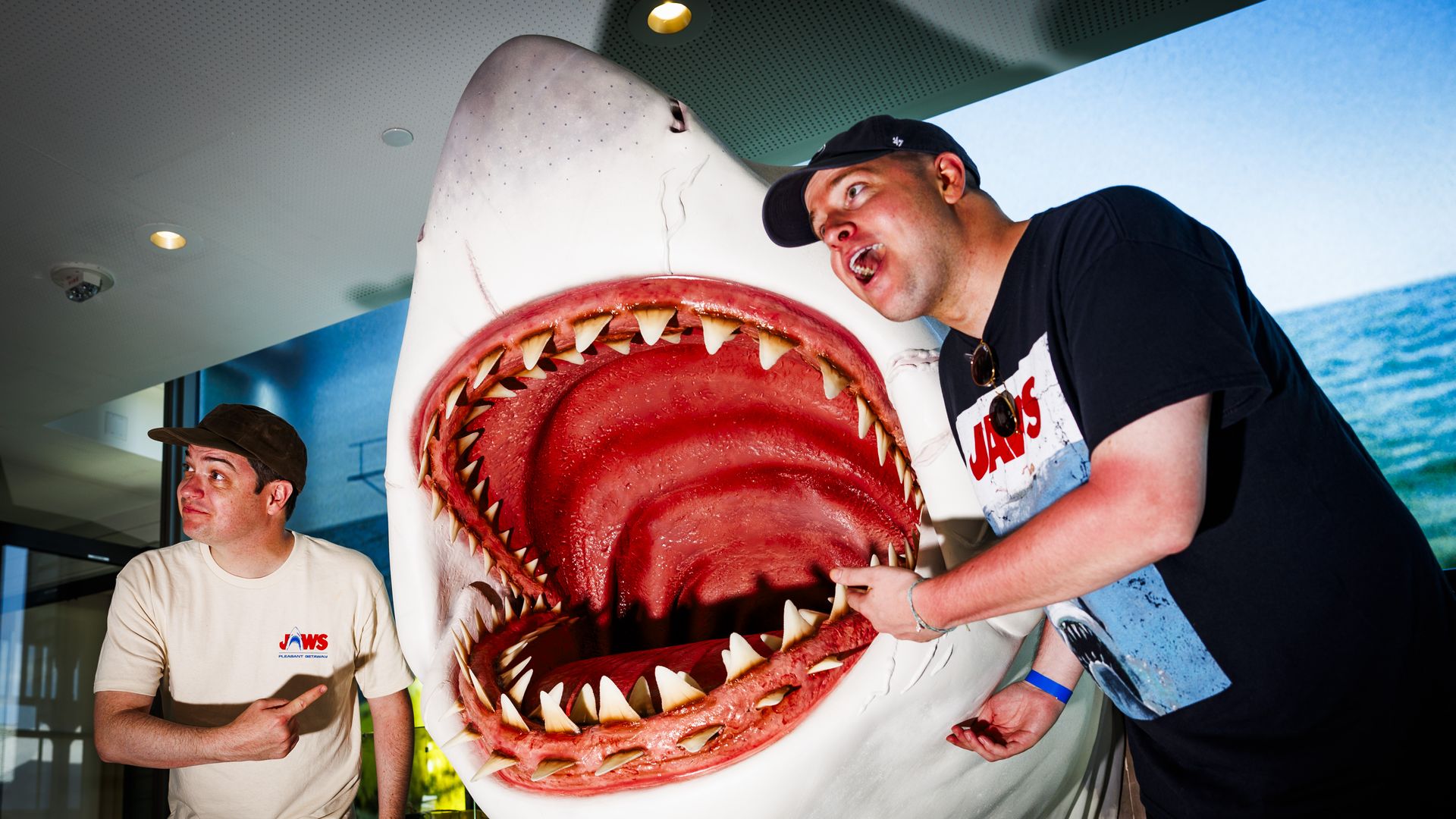 Men pose with a fake shark
