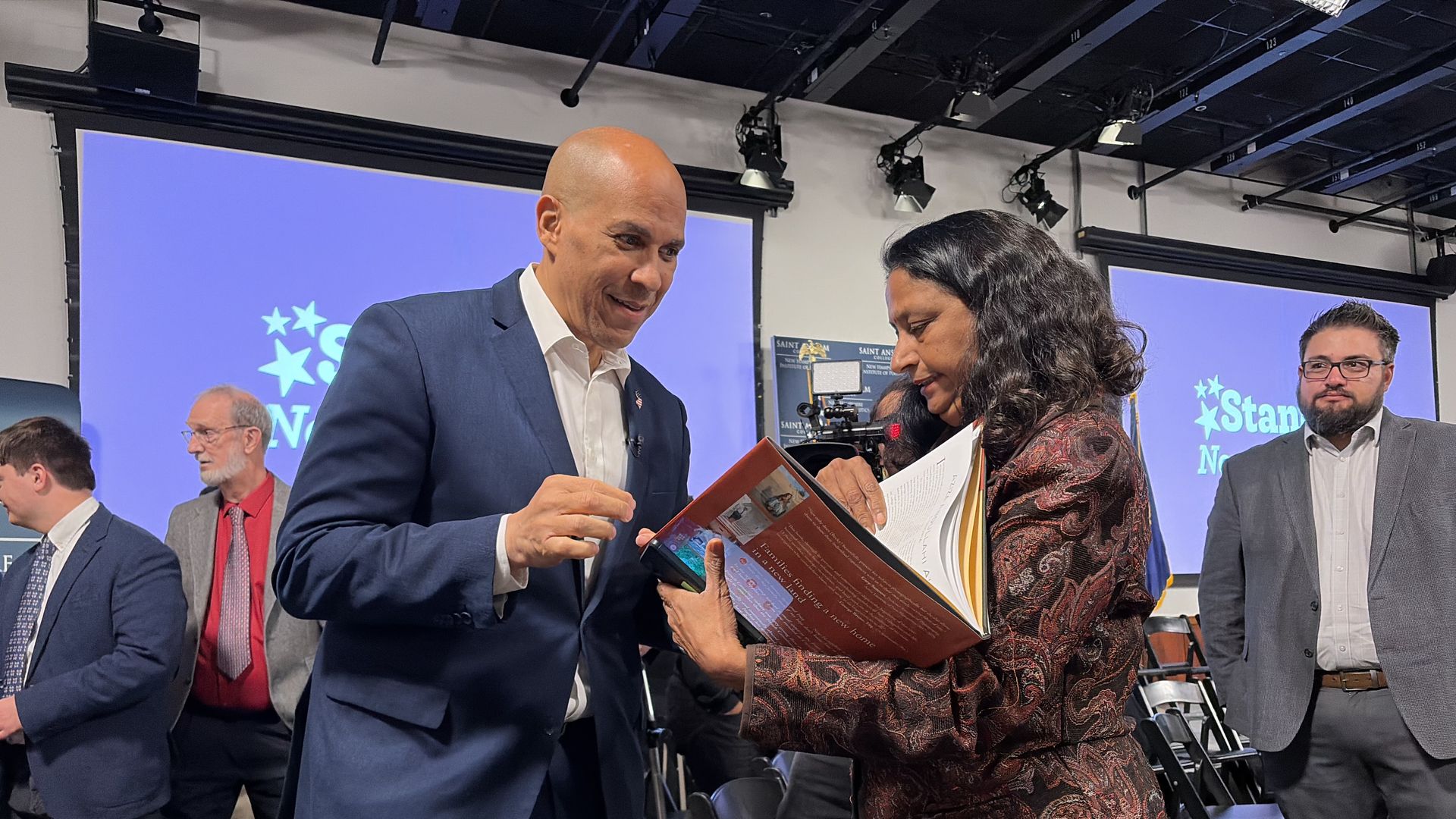 Sen. Cory Booker (D-N.J) autographs a book for a woman.