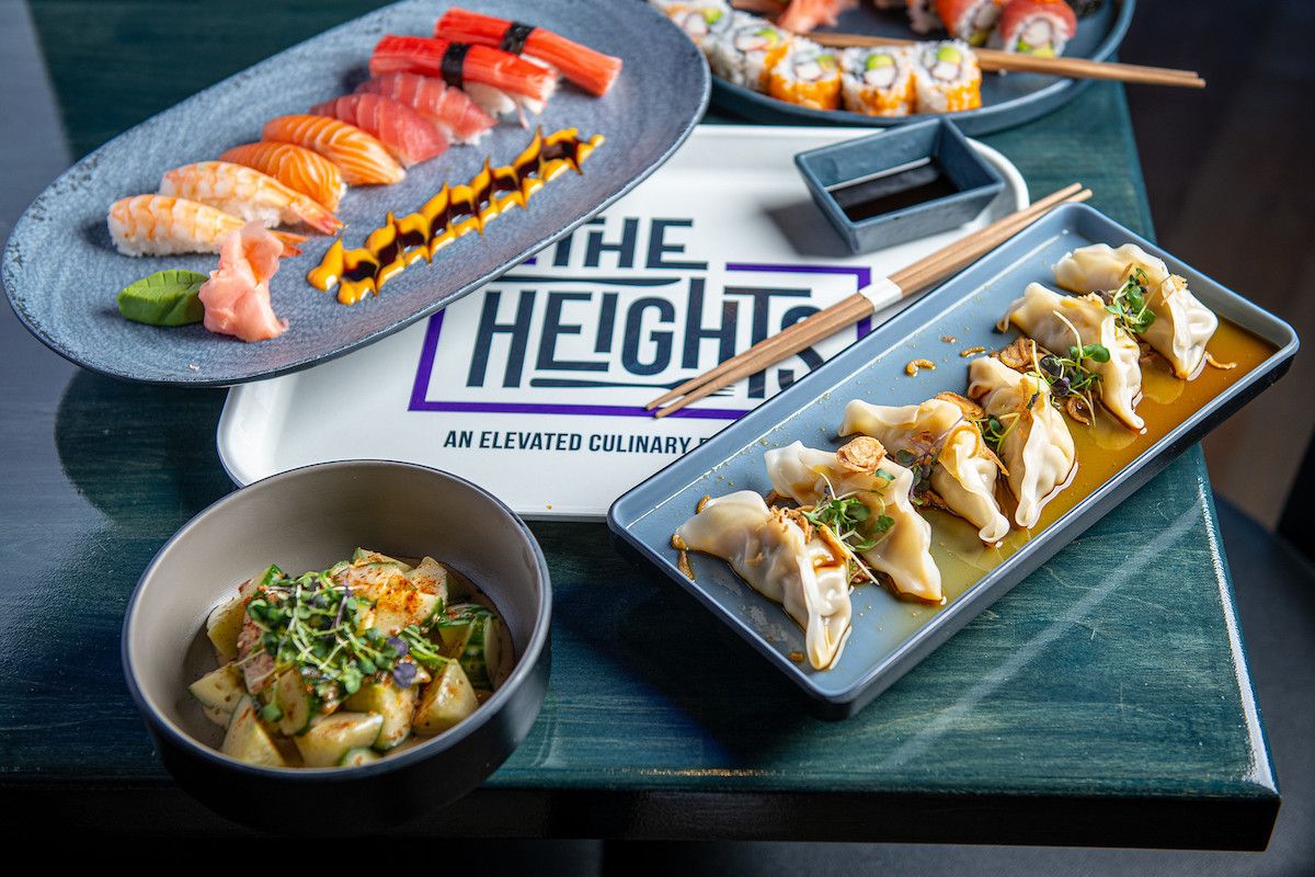 A platter of sushi, dumplings and cucumber salad 