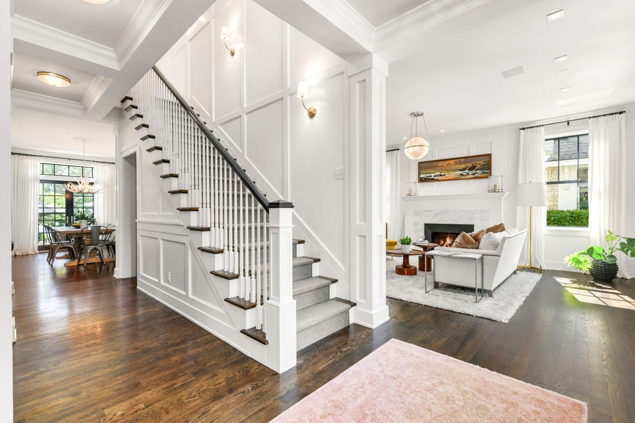 open-concept entry with stairs and view of living and eating areas