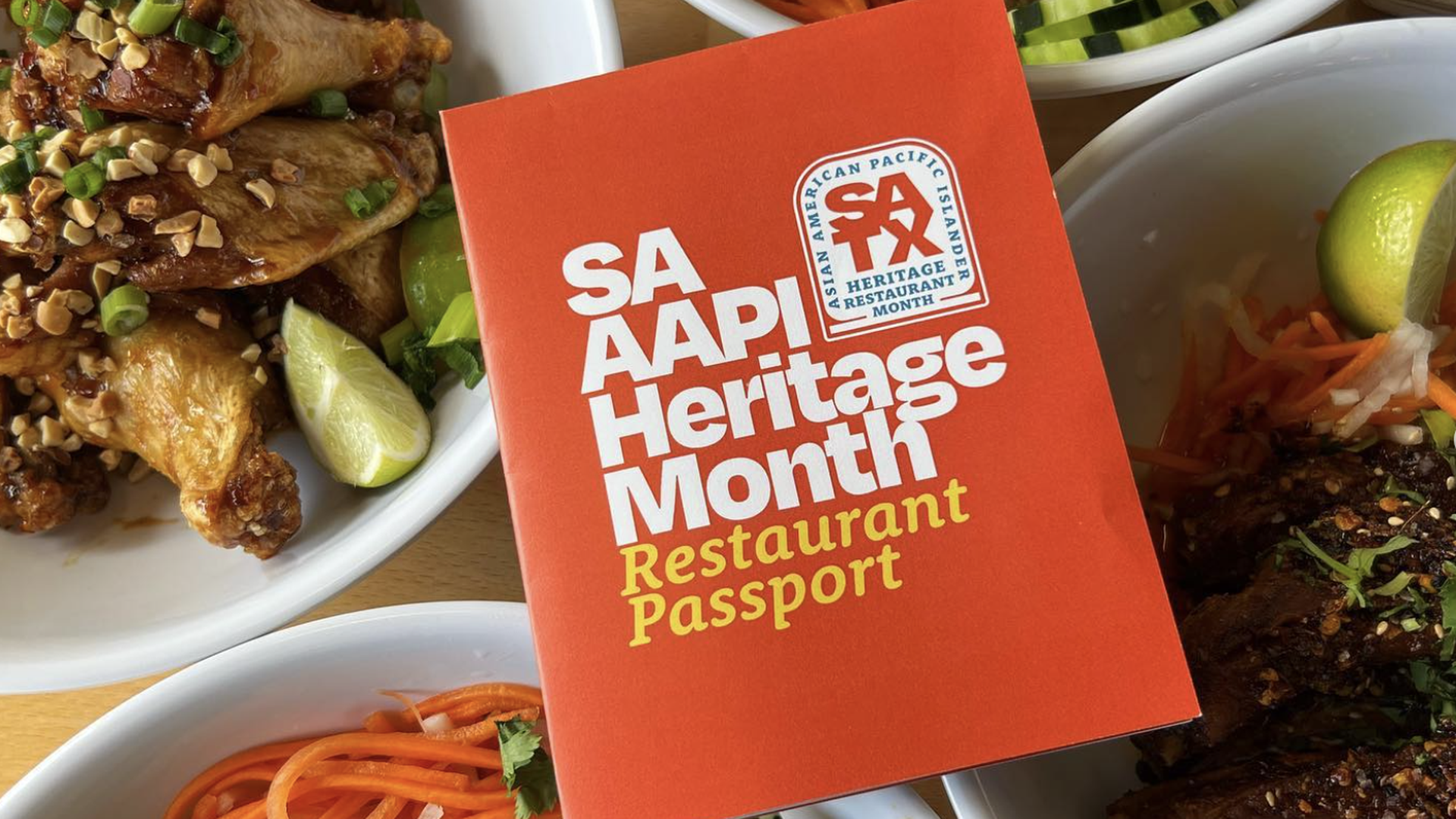 A red booklet titled SA AAPI Heritage Month Restaurant Passport sits on a four bowls of Vietnamese food.