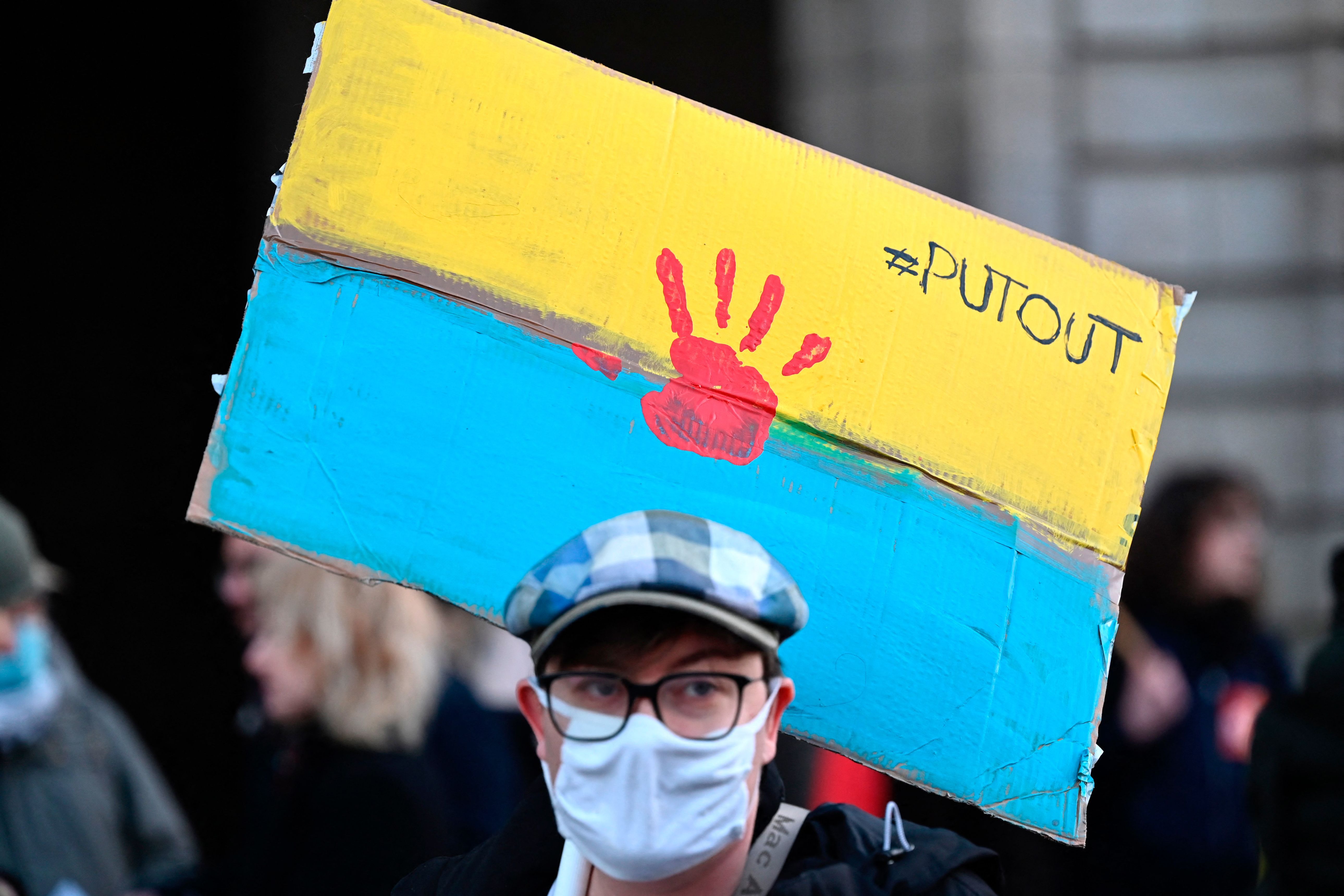  A protester holds a placard in the colour of the Ukrainian flag during a rally against Russia's military operation in Ukraine during a rally in Rennes, western France on February 24.