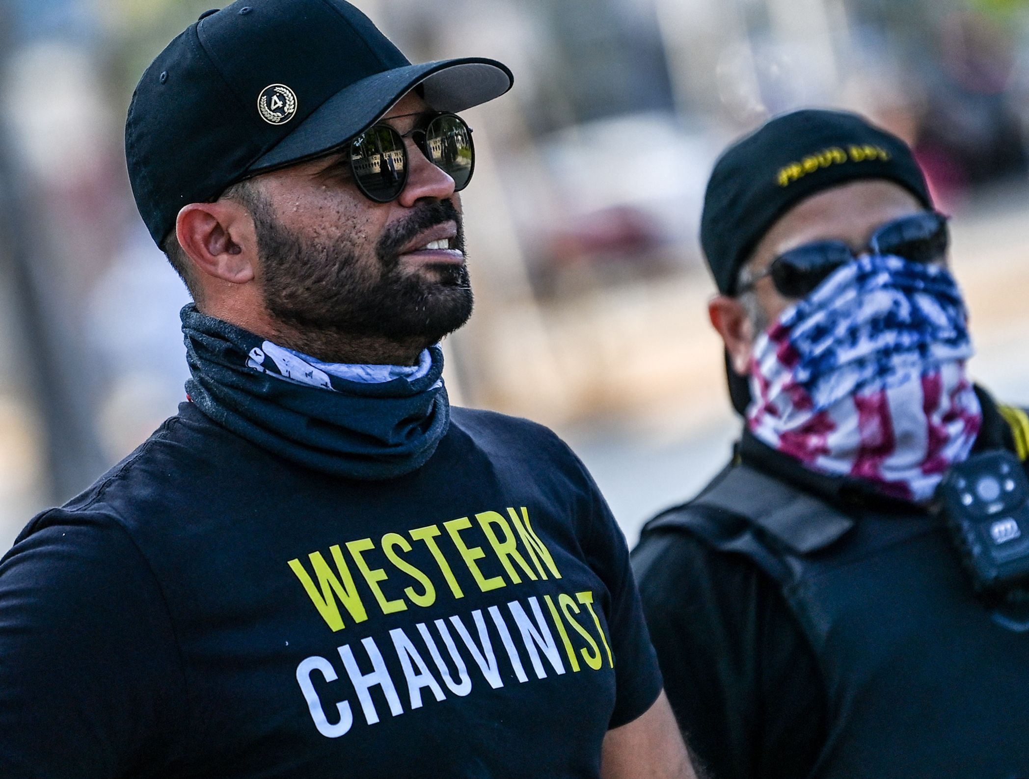 Proud Boys leader Enrique Tarrio, wearing a shirt supporting Derek Chauvin, watches protest on the one-year anniversary of his death at the hands of a police officer, in Miami.