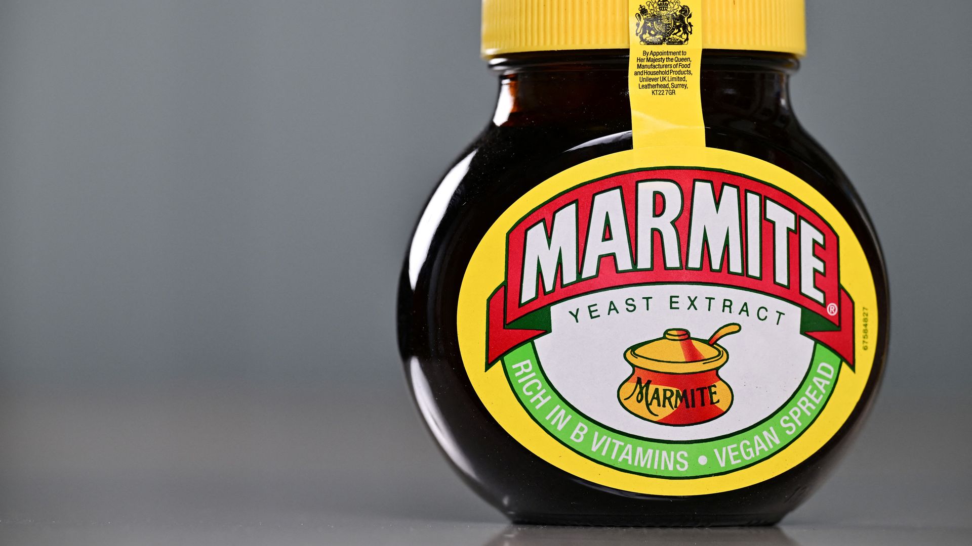 A jar of Marmite in yellow, black, white and green packaging