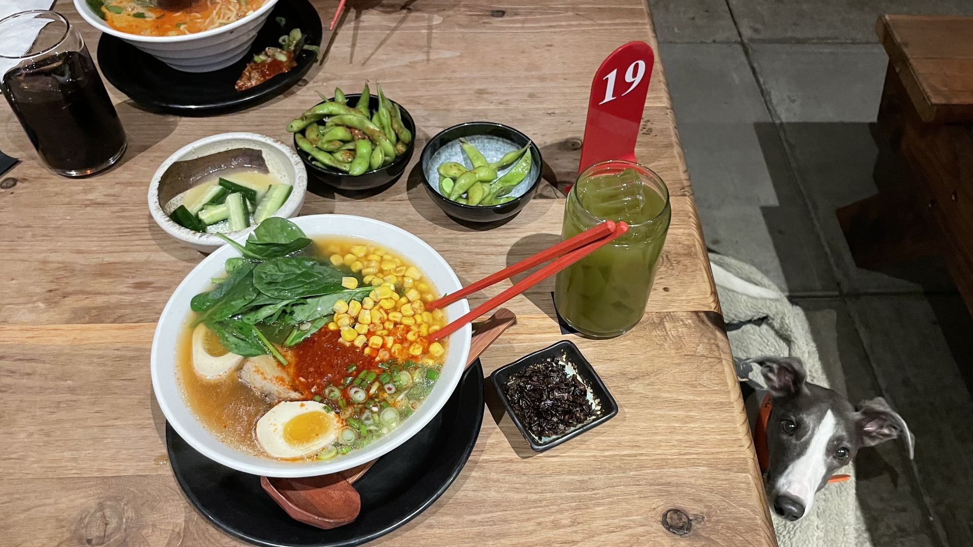 A photo of a table with a bowl of ramen noodle soup. 