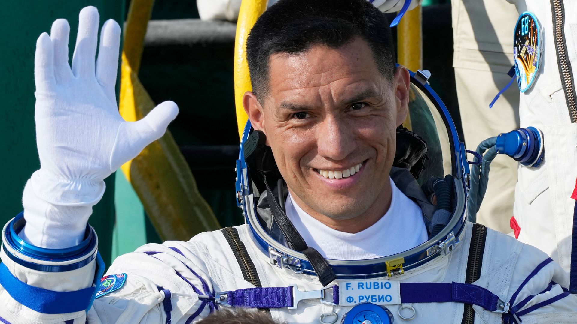 NASA astronaut Frank Rubio waves to a crowd before boarding a spacecraft