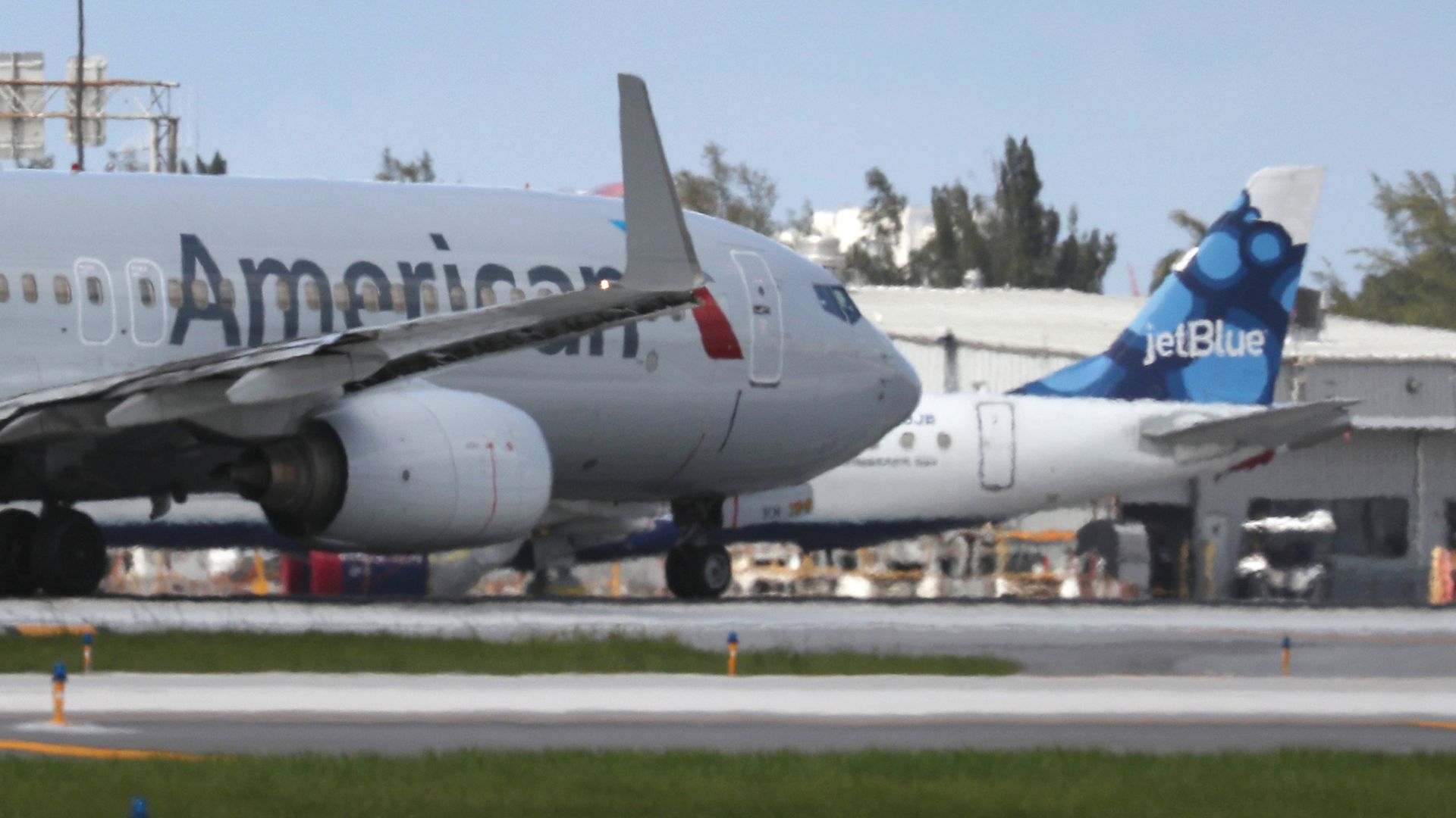 An American Airlines plane takes off near a parked JetBlue plane at the Fort Lauderdale-Hollywood International Airport on July 16, 2020 in Fort Lauderdale, Florida. 