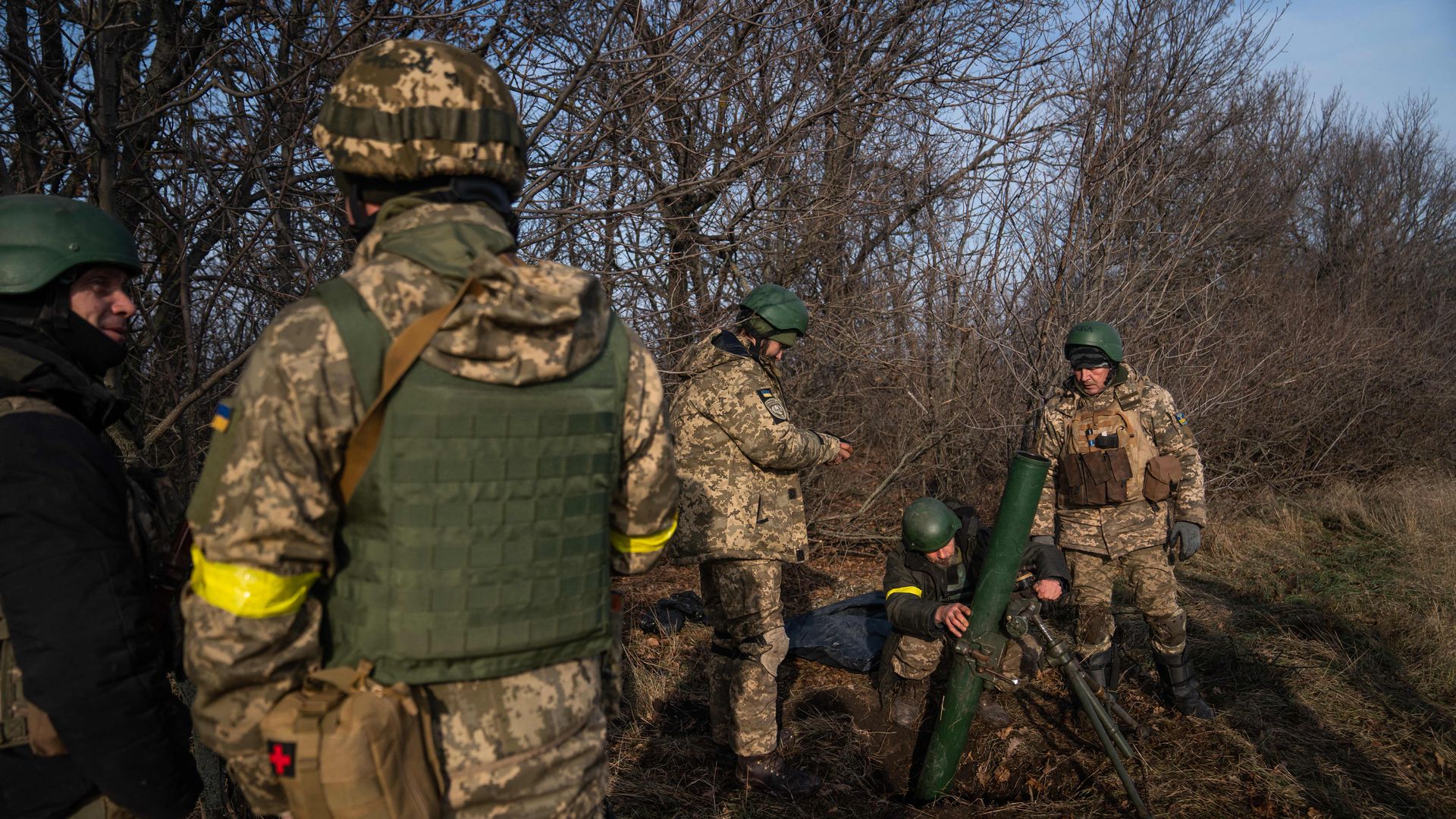 Ukrainian soldiers from the 68th brigade adjust a mortar launcher at a position along the front line in Donetsk region on December 9, 2022.