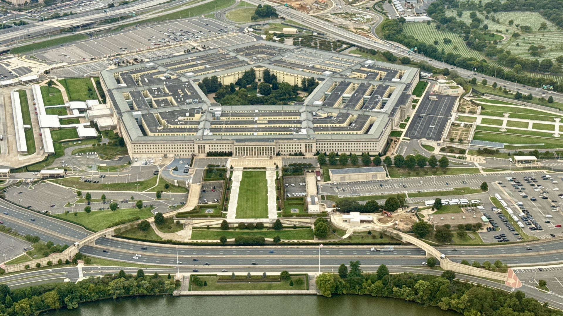 An aerial view of the Pentagon, with its surrounding infrastructure: parking lots, roads, green spaces.