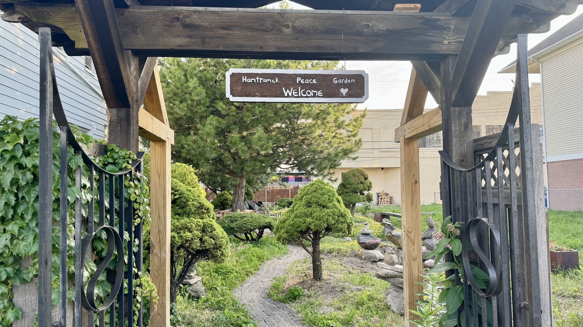 A green garden with a gate that says "Hamtramck Peace Garden"