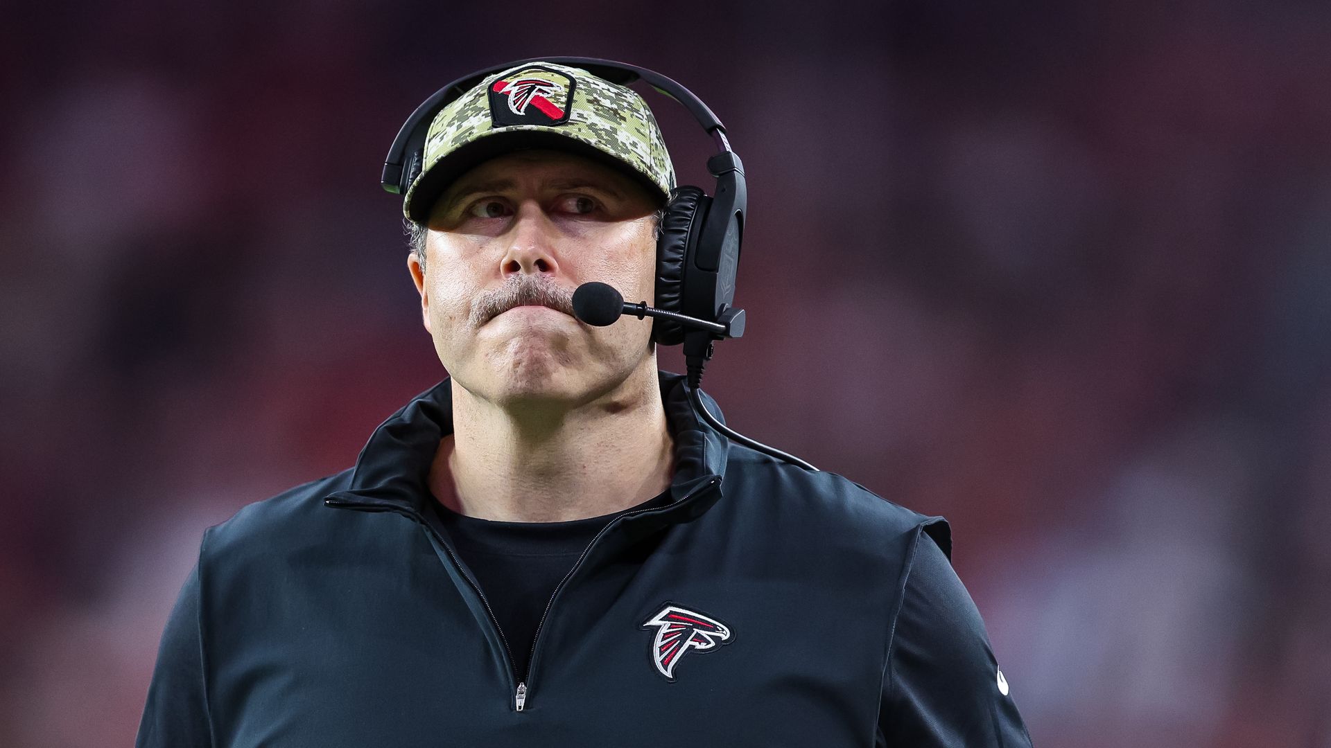 A man in a black shirt and wearing a hat