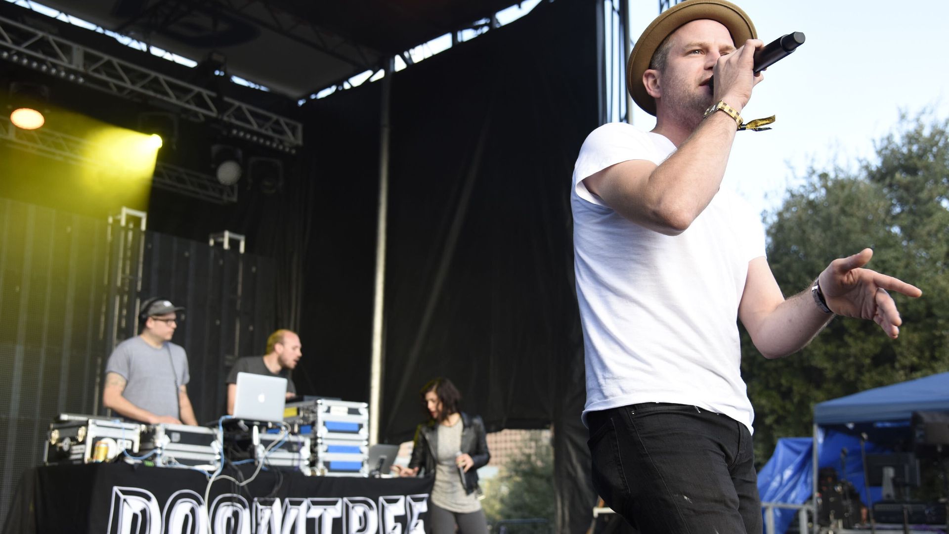 Rapper Lazerbeak wears a white shirt and holds a mic 