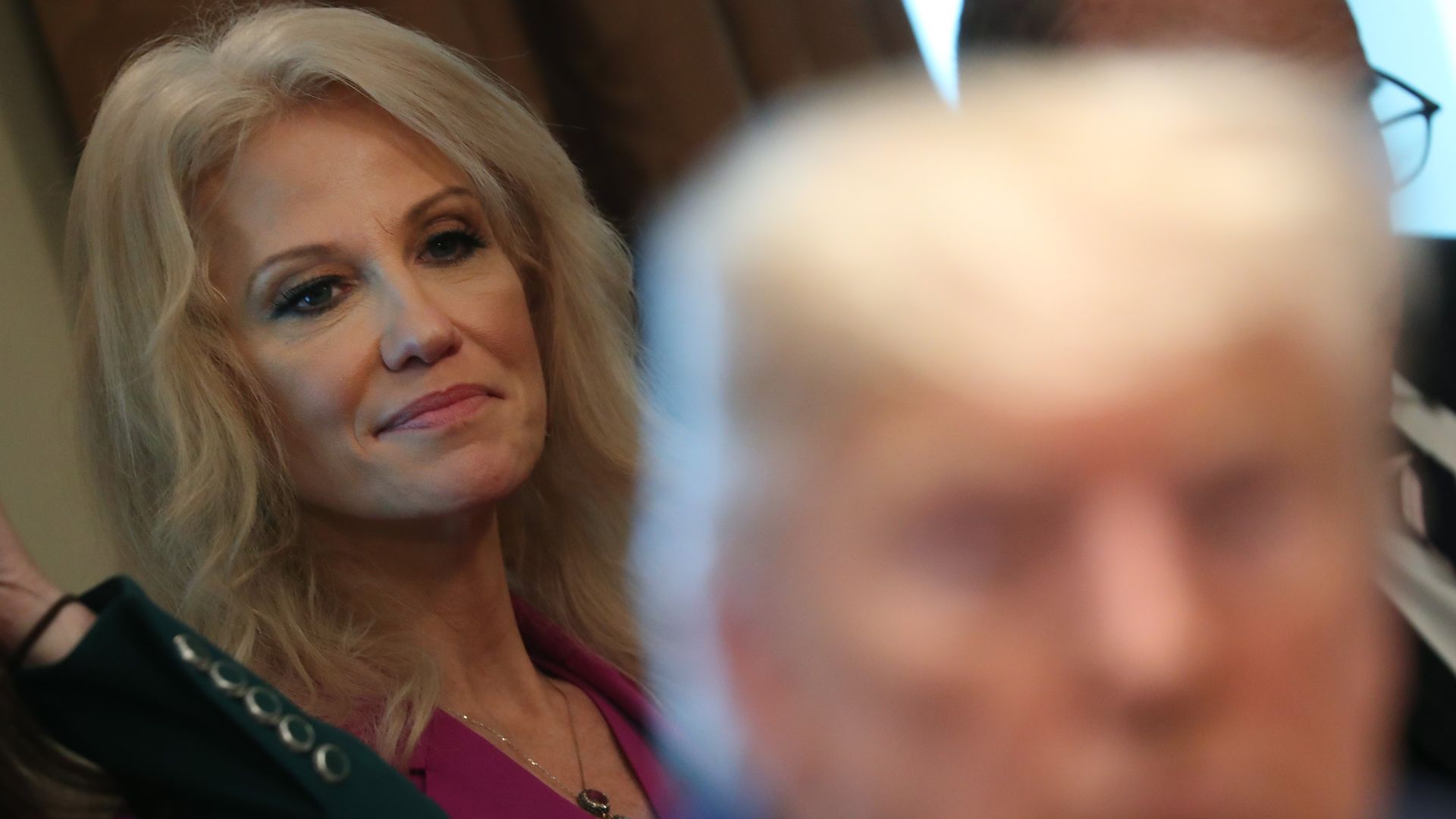 White House counselor Kellyanne Conway listens to U.S. President Donald Trump.