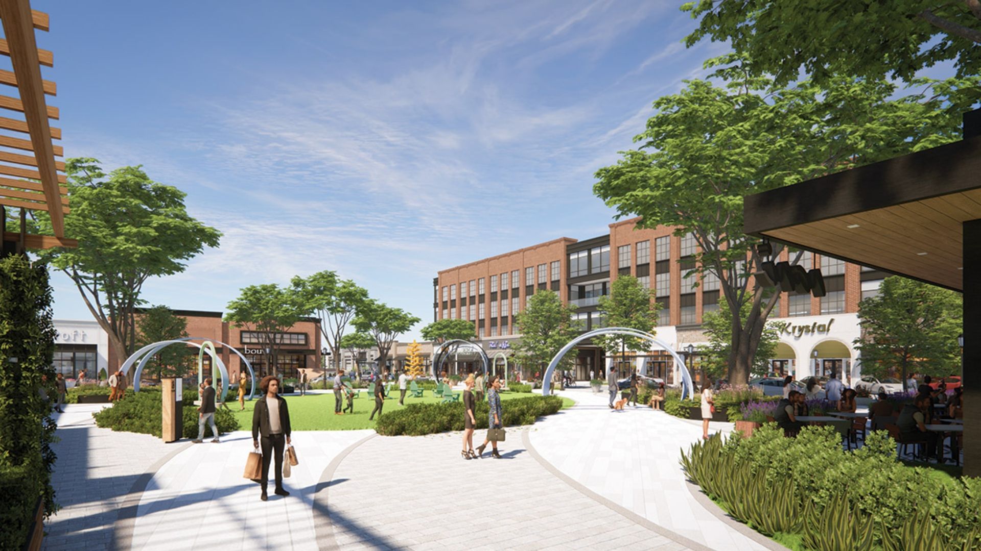 Sunny urban plaza with brick storefronts, green trees, and modern curved metal arches. People walk, sit at outdoor tables, and landscaped planters line wide, light-paved walkways under a blue sky.