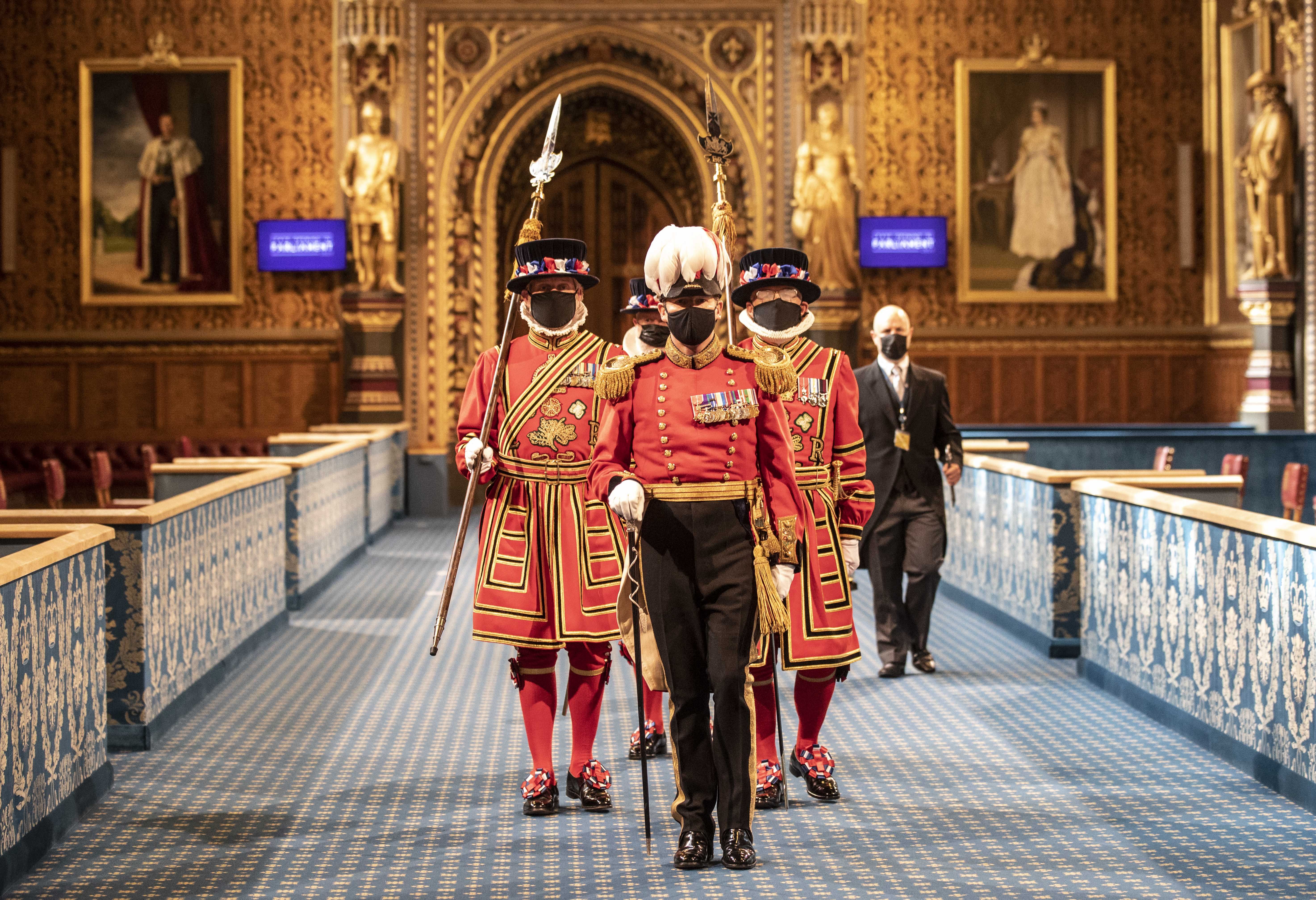 A photo of Yeoman standing in parliament while wearing masks.