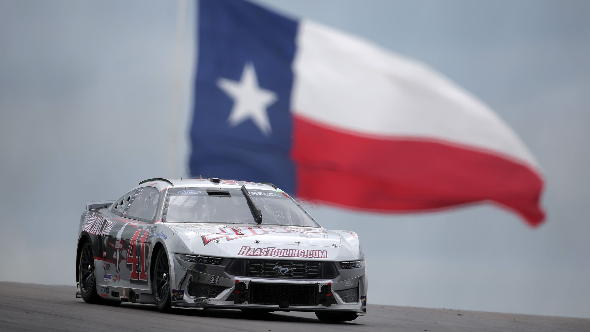a photo of a car with a texas flag in the background.