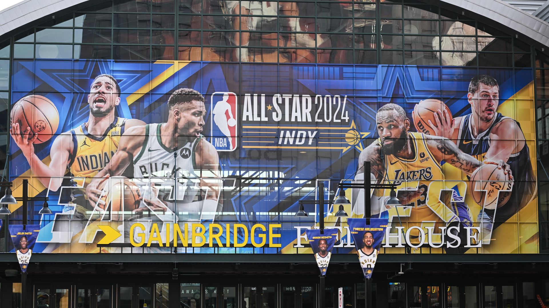 A poster of basketball players on the side of a building. 