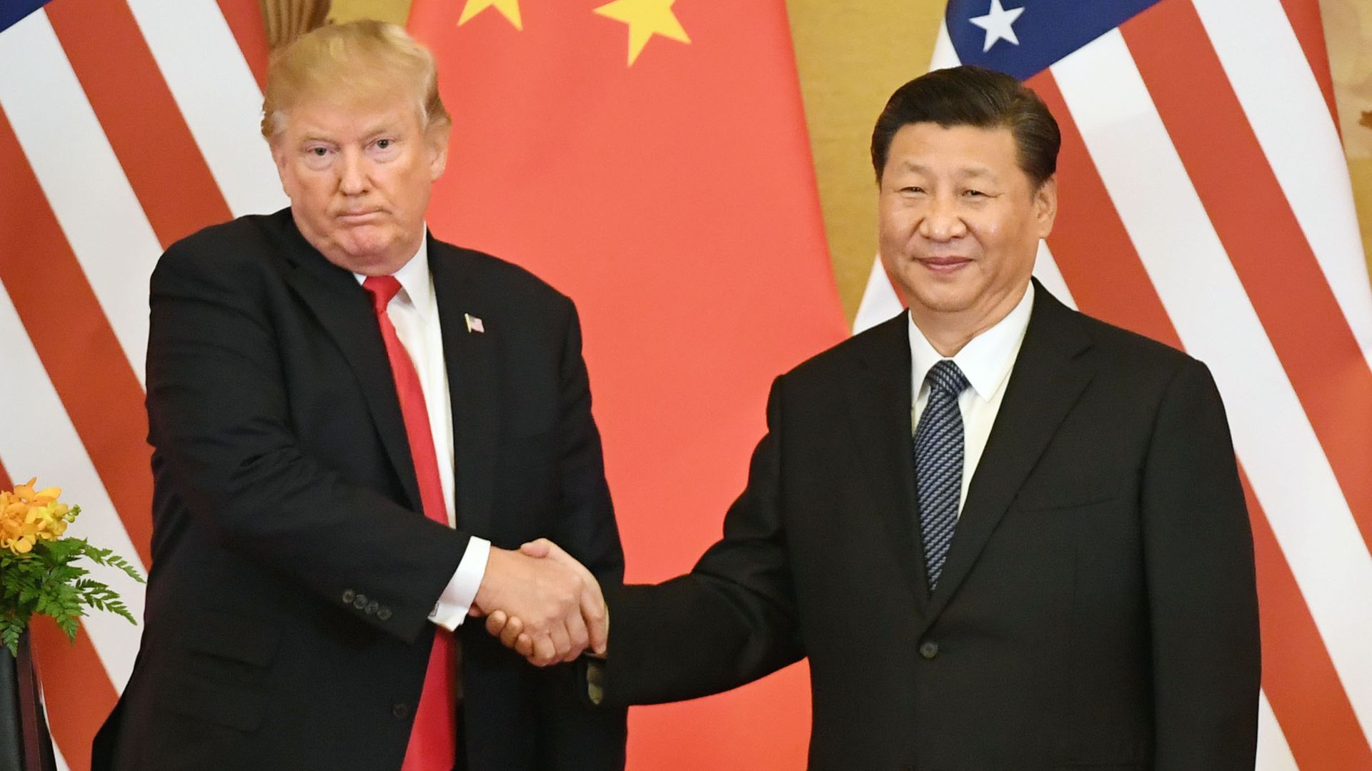 Donald Trump shakes Xi Jinping's hand.