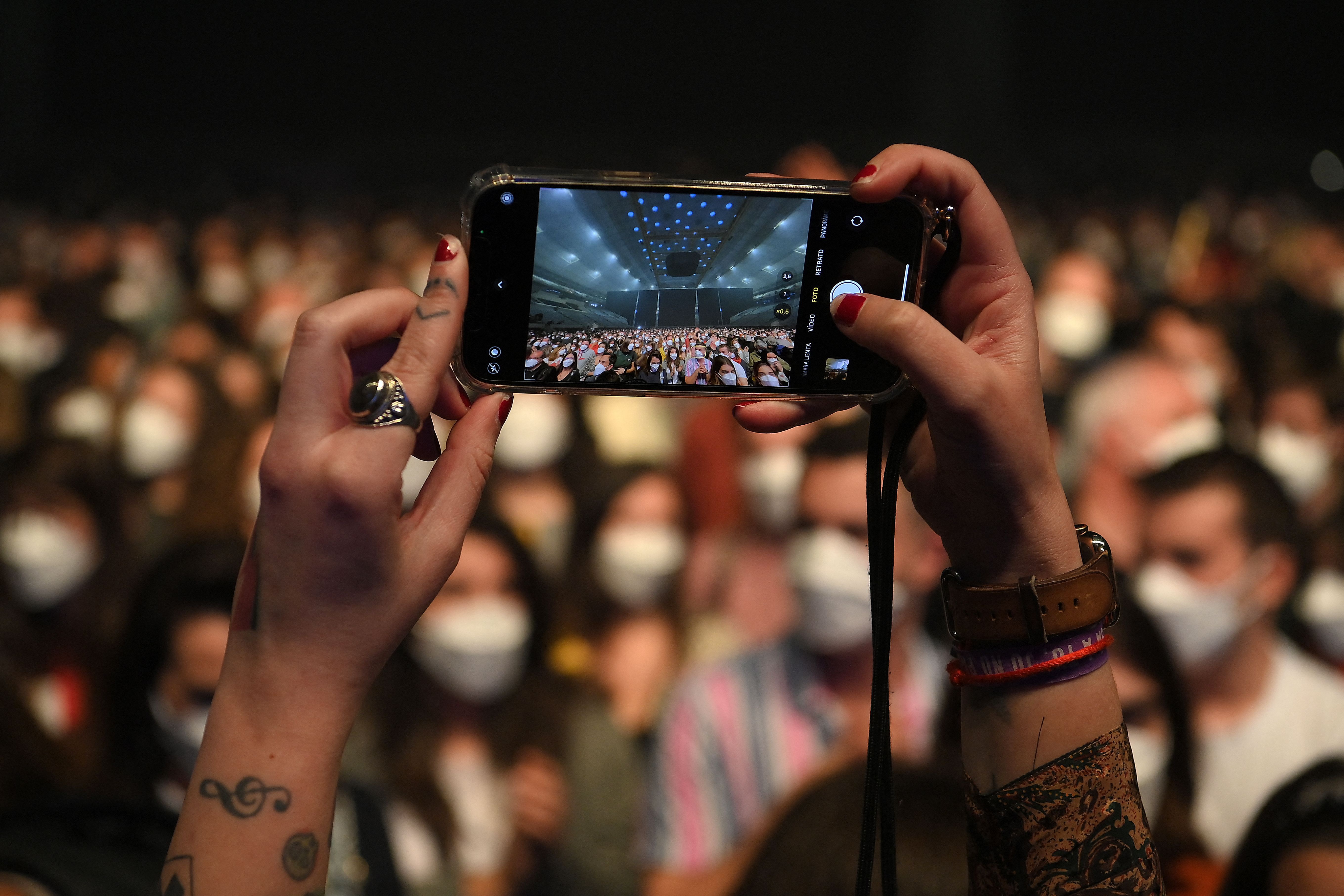 A spectator takes a picture before the start of a rock music concert by Spanish group Love of Lesbian at the Palau Sant Jordi in Barcelona on March 27