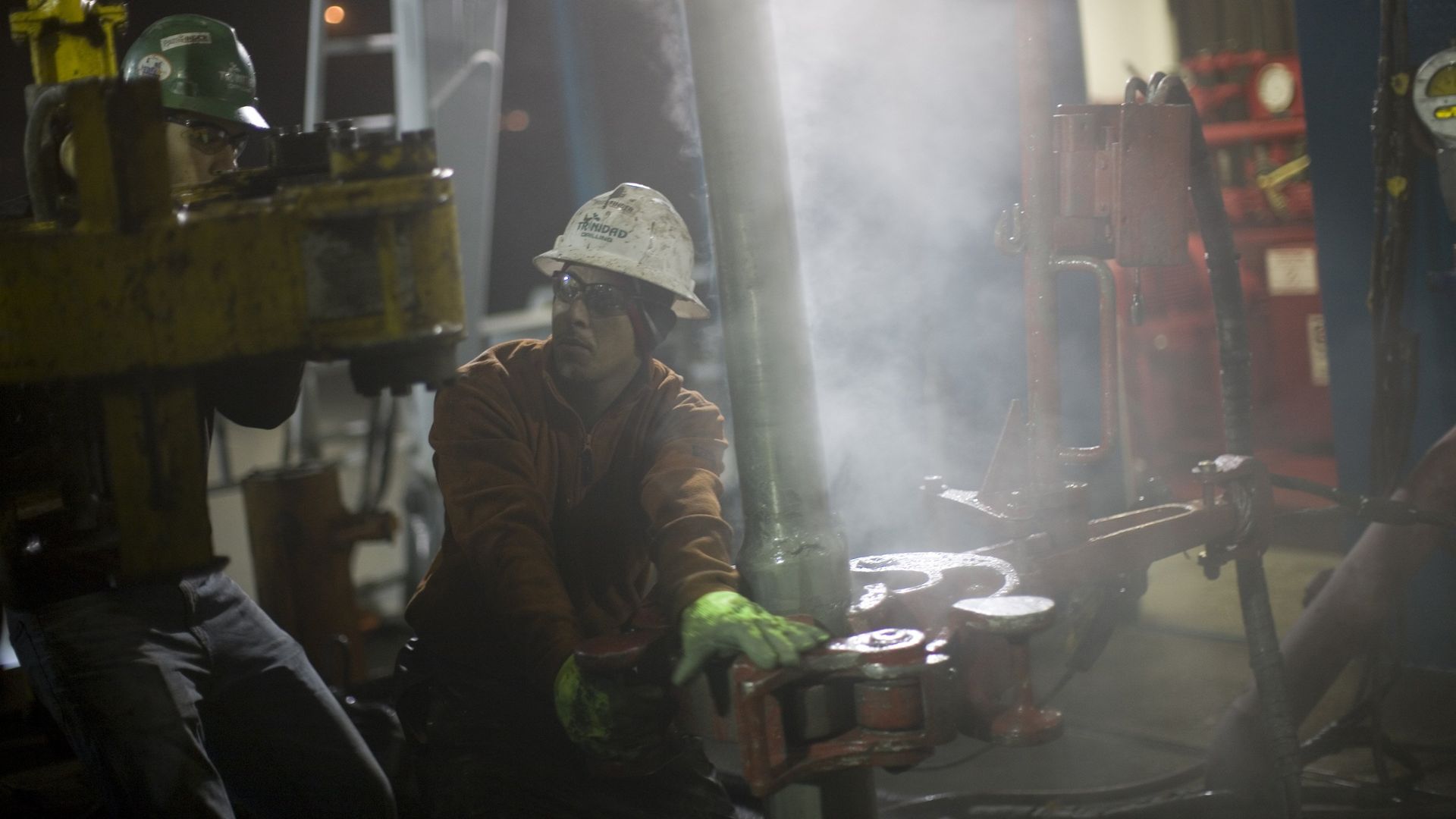 A floor crew pulls steel pipe out of a natural gas well in the Barnett Shale on December 18, 2008 in Fort Worth, Texas.
