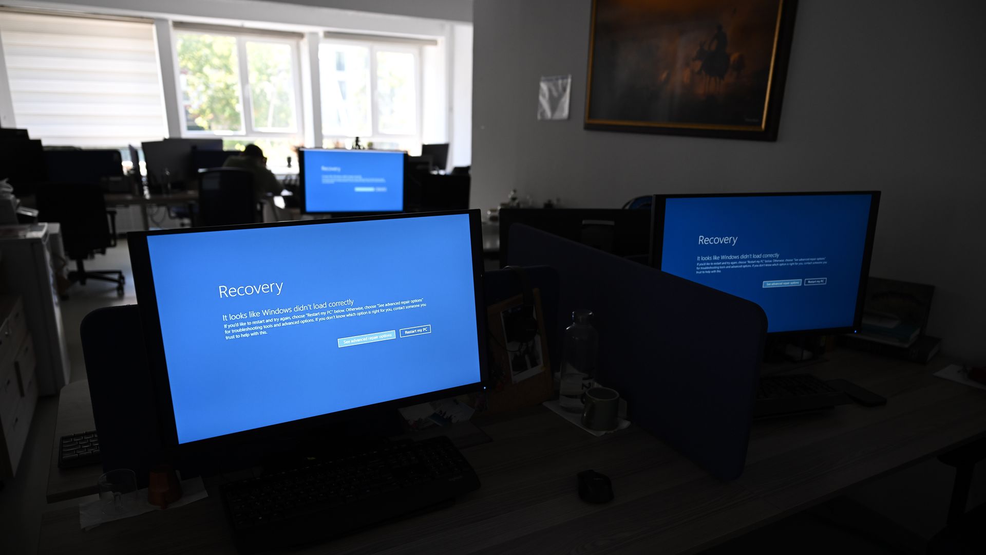 Image of three computers with a "Blue Screen of Death" window