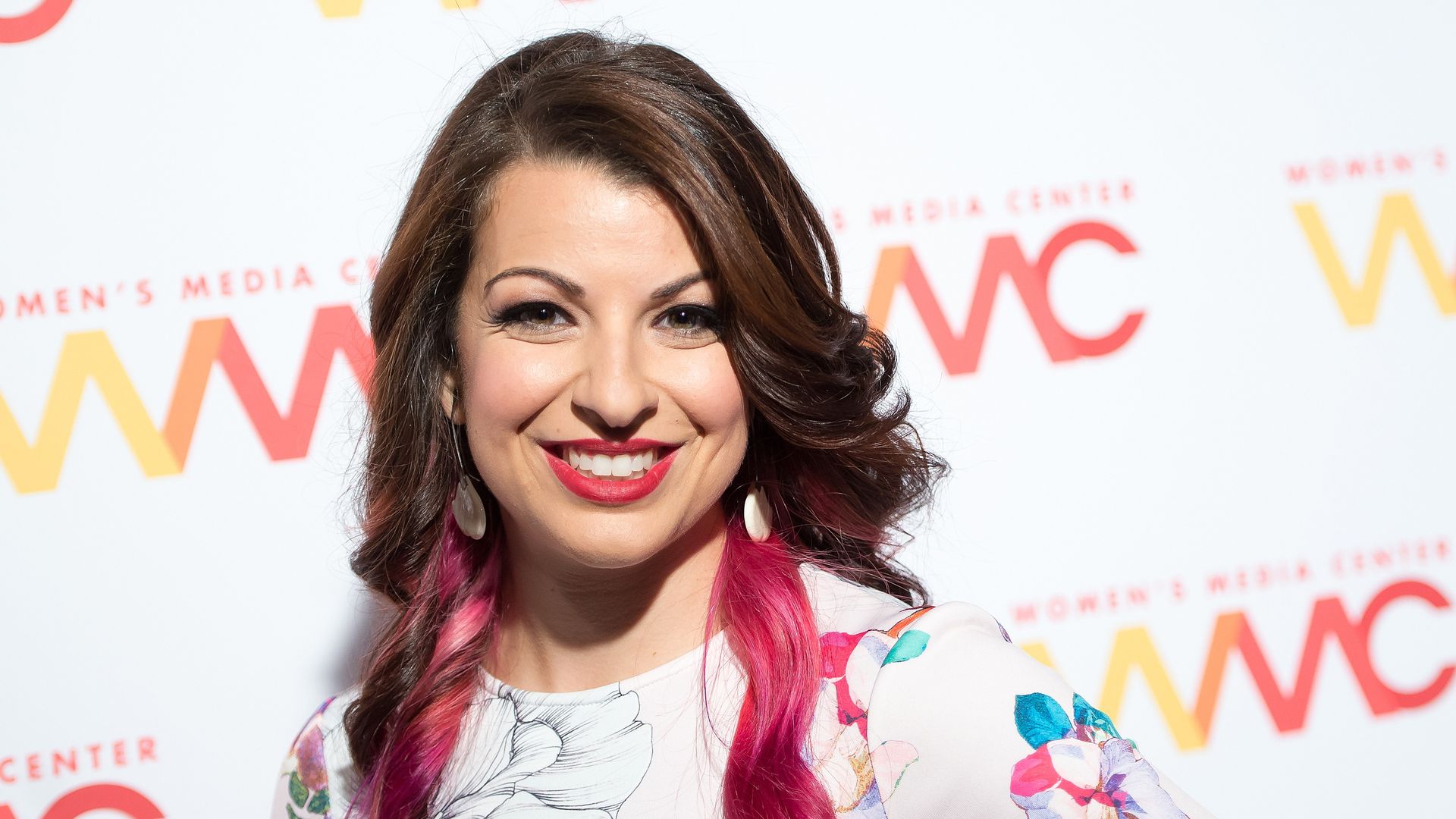 A red carpet photo of Anita Sarkeesian smiling at the camera.